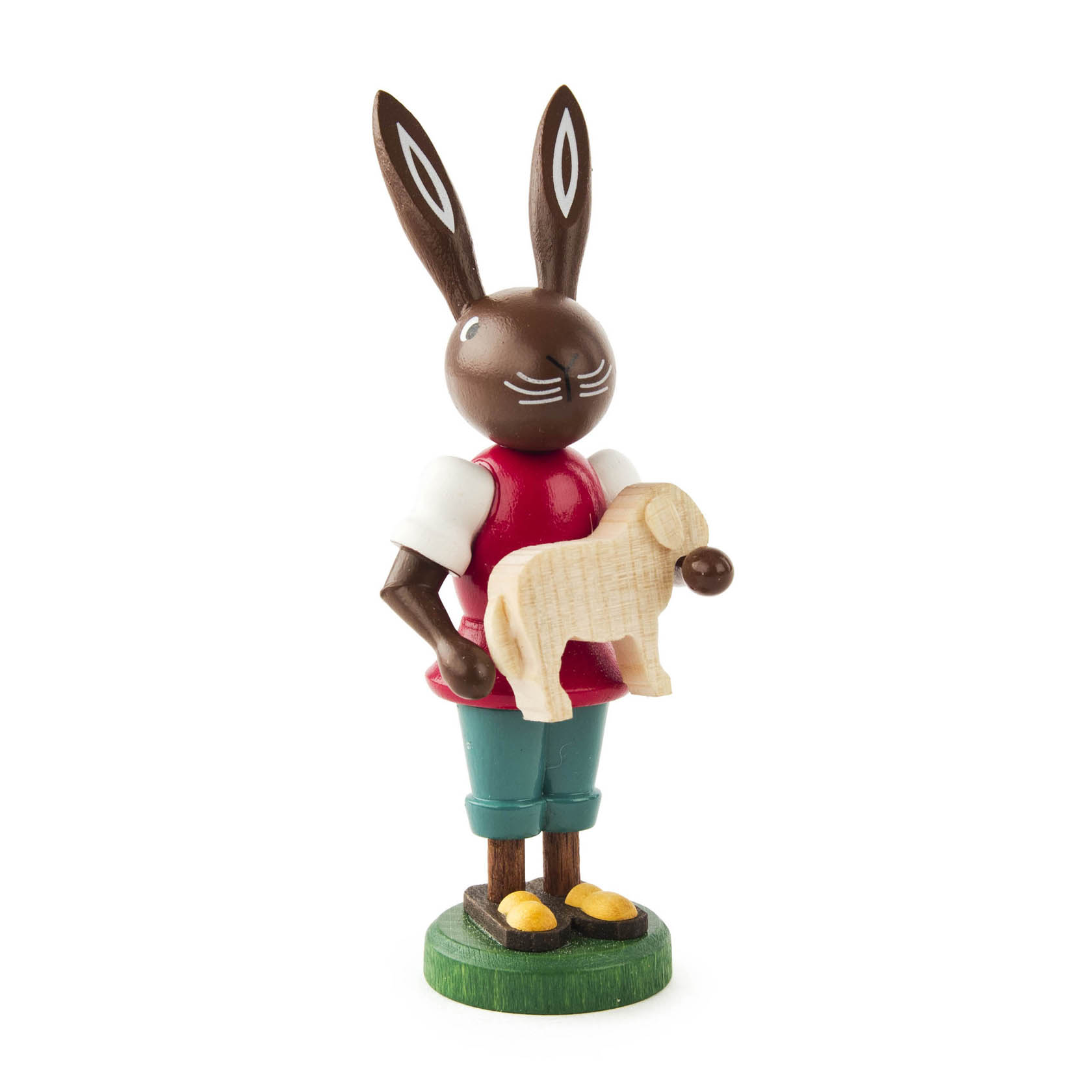 Holzfigur eines Hasen mit einem weißen Schäfchen im Arm, rot-weiß bekleidet und auf einem grünen Sockel stehend. im Dregeno Online Shop günstig kaufen