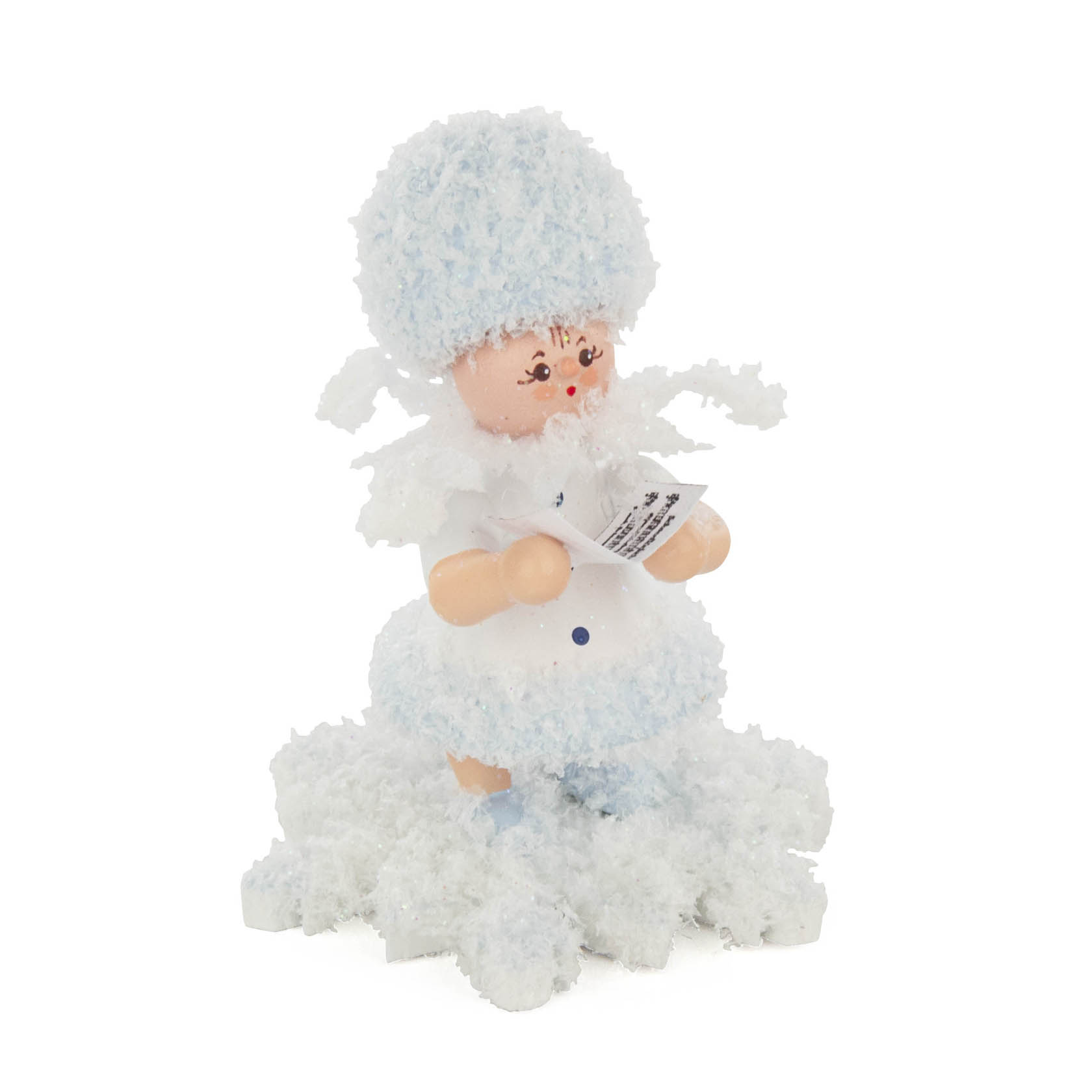A figurine of a small, smiling snow child dressed in fluffy white and light blue attire, holding a songbook in its hands, standing on scattered snowflakes. im Dregeno Online Shop günstig kaufen