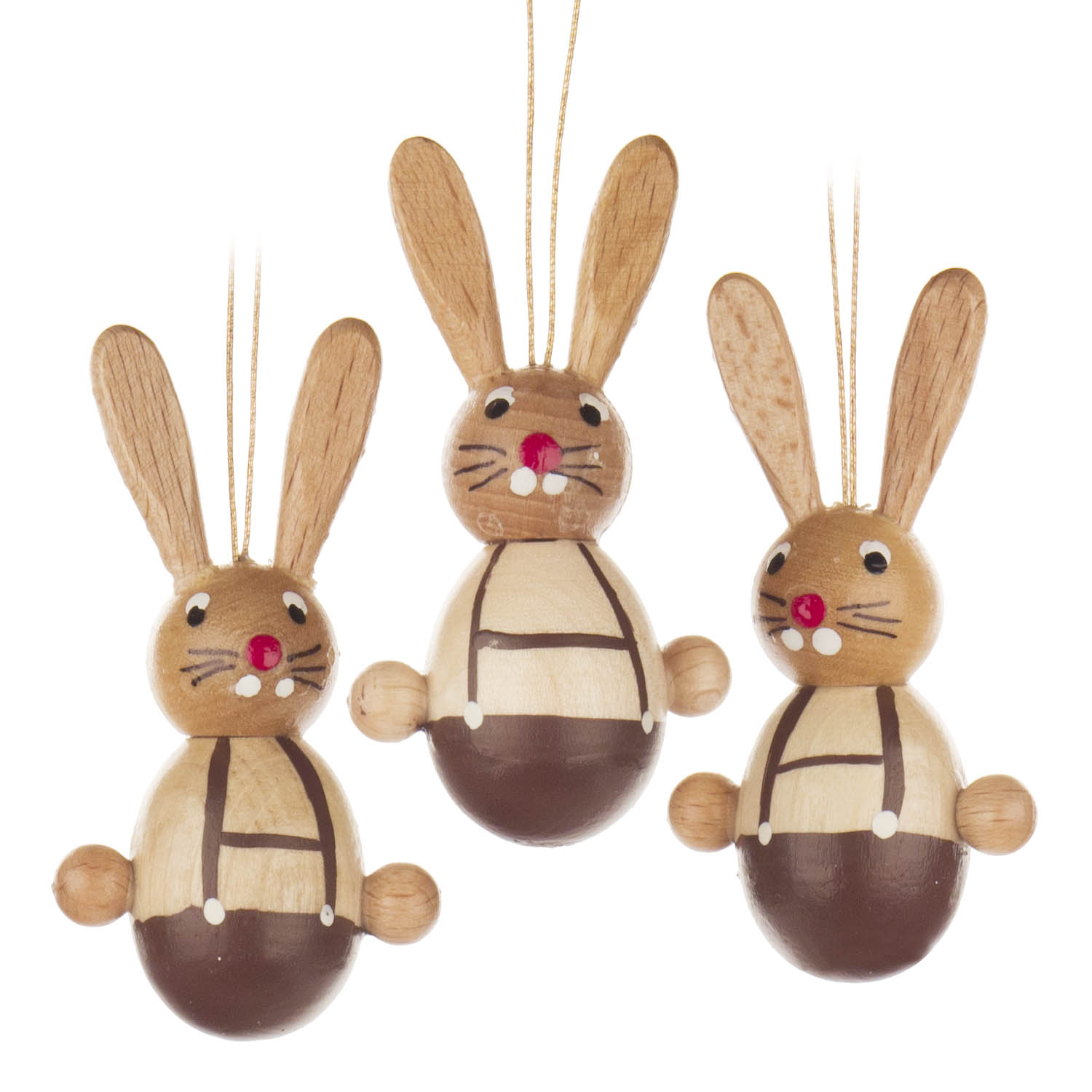 Drei hölzerne Hasenfiguren mit langen Ohren und gemalten Gesichtern. Sie tragen braune Hosen und sind als Dekoration zum Aufhängen vorbereitet. im Dregeno Online Shop günstig kaufen