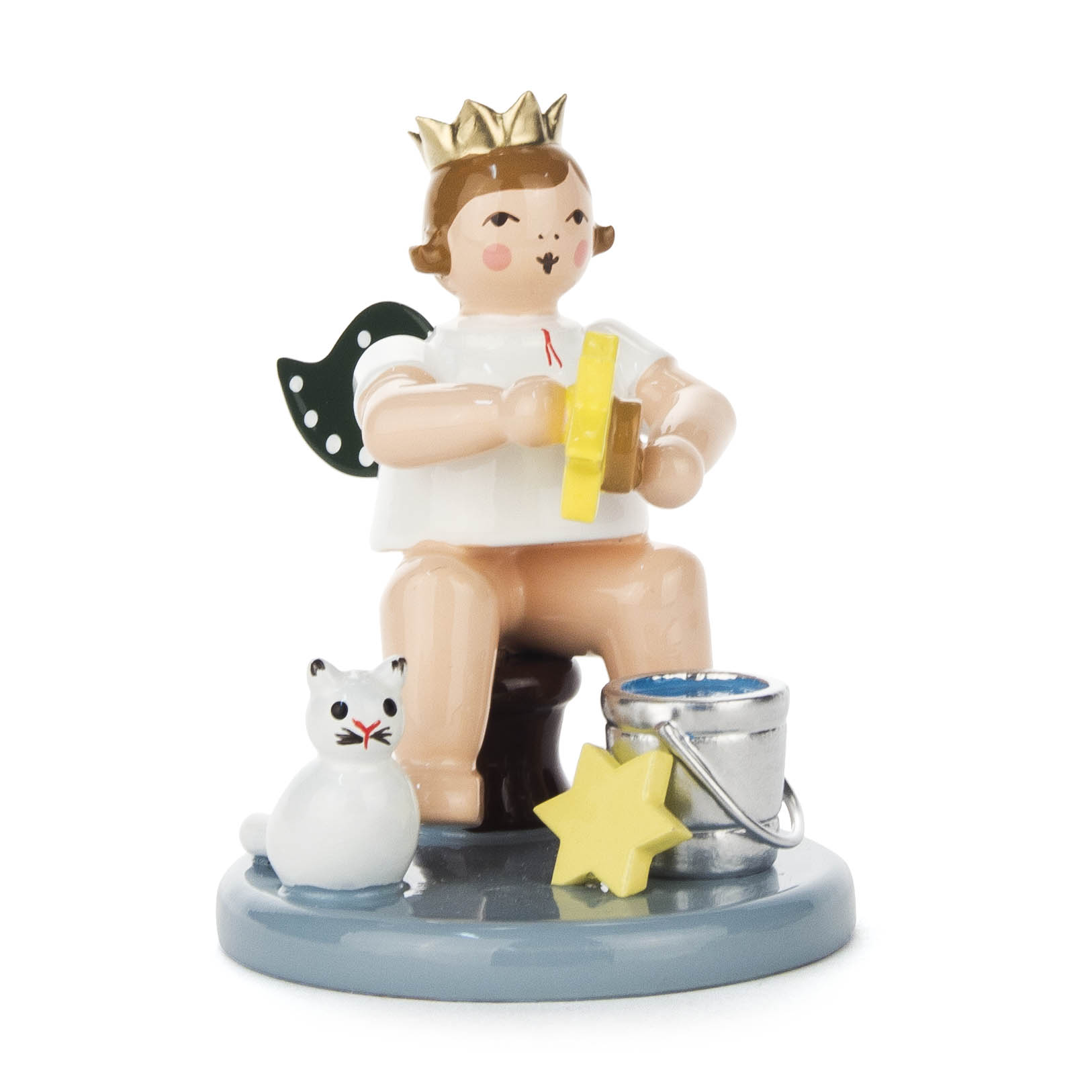 Ein Engel mit grünen Flügeln und goldener Krone, sitzt auf einem Hocker. Er hält ein gelbes Band und ist von einem Eimer, einem Stern und einer weißen Katze begleitet. im Dregeno Online Shop günstig kaufen