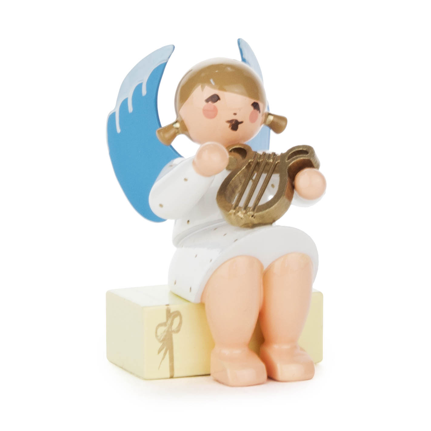 Ein Engel mit blauen Flügeln und goldener Lyra sitzt auf einem cremefarbenen Geschenkpaket. im Dregeno Online Shop günstig kaufen