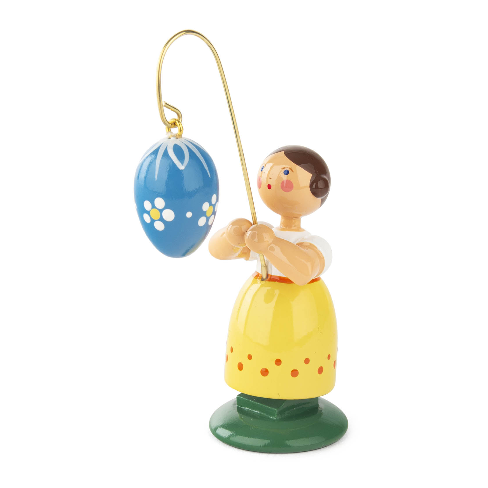 Eine Holzfigur eines Mädchens in gelbem Rock, das ein blaues Osterei an einem goldenen Draht hält. im Dregeno Online Shop günstig kaufen