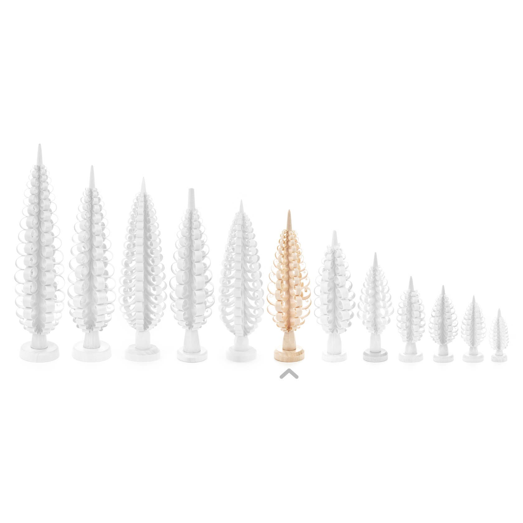 A series of pyramid-shaped wooden trees of various sizes, predominantly white with one in natural wood color standing out.