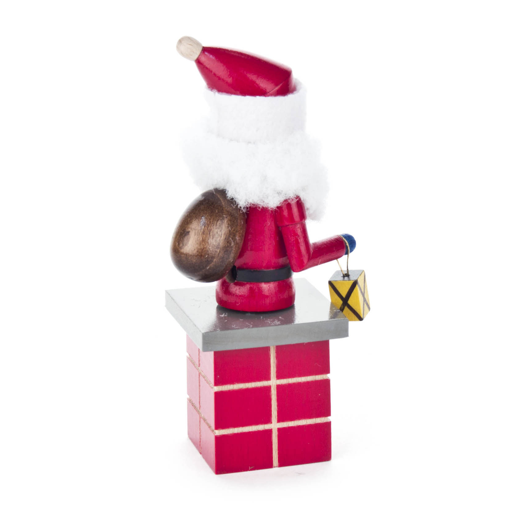 Ein kleiner Räuchermann in Form eines Weihnachtsmanns steht auf einem roten Schornstein. Er trägt eine rote Mütze, hat einen Sack auf dem Rücken und hält eine Laterne.