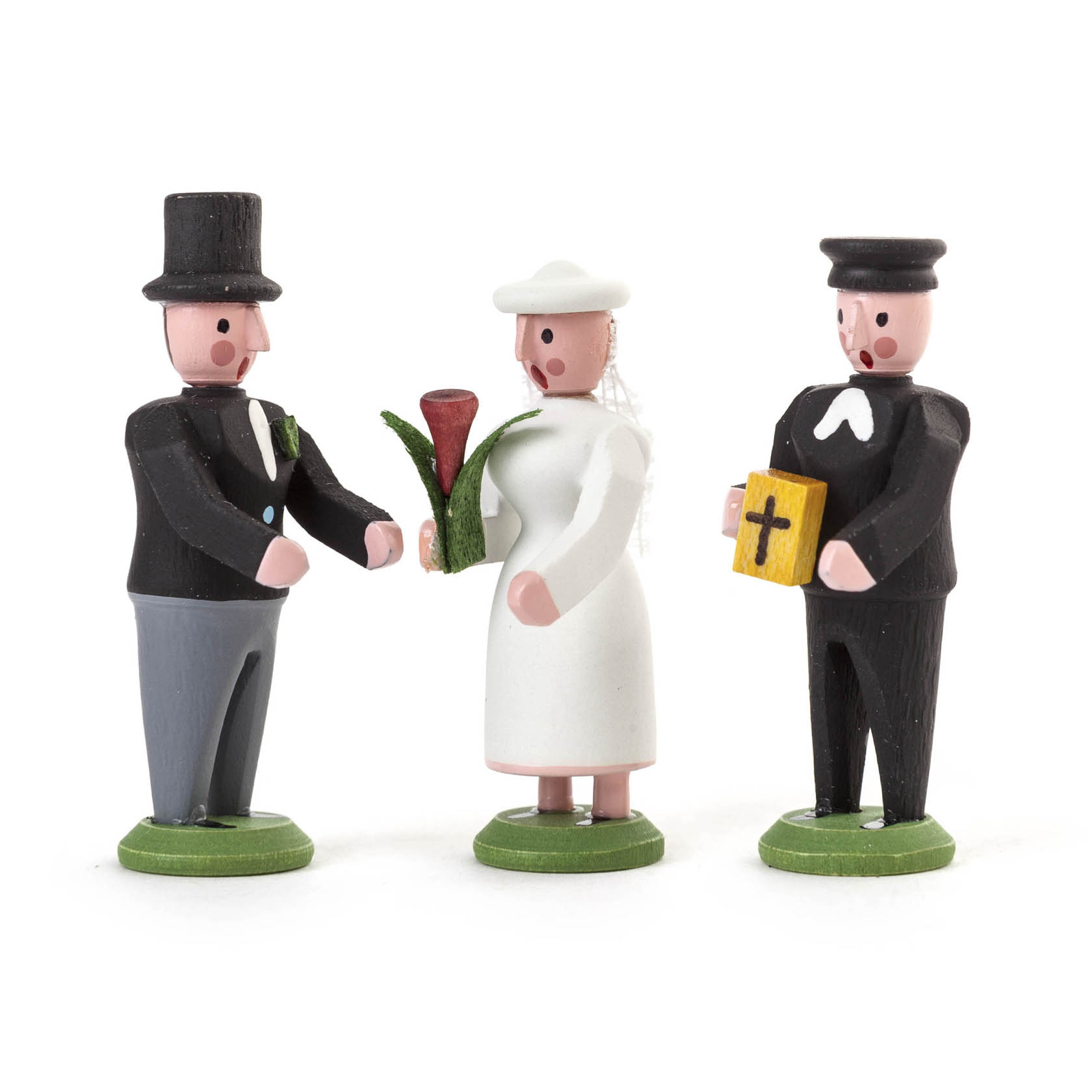 Drei Miniaturfiguren: Ein Bräutigam im schwarzen Frack und Zylinder, eine Braut im weißen Kleid mit Blumenstrauß und ein Pfarrer mit Bibel und schwarzem Anzug. im Dregeno Online Shop günstig kaufen