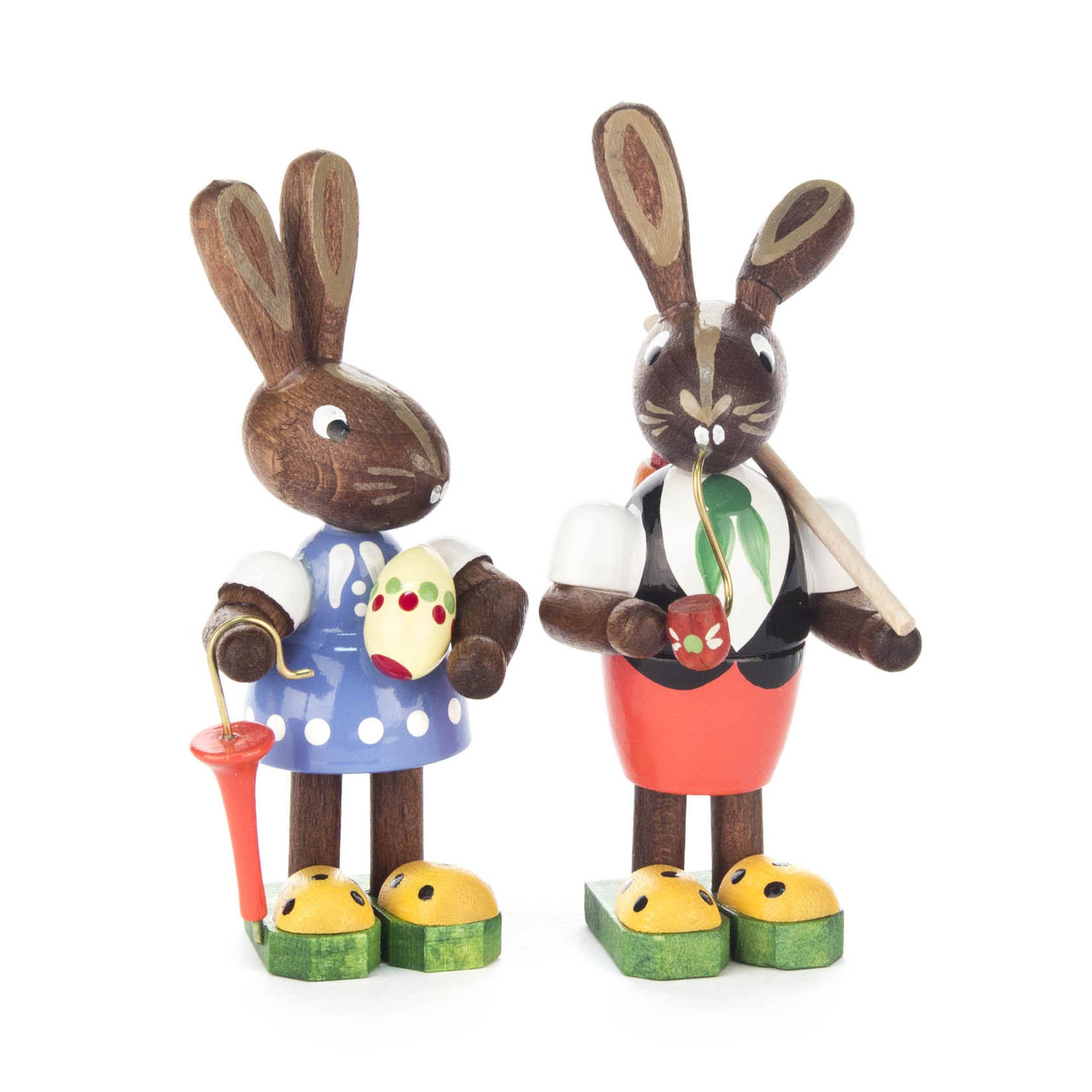 Zwei Hasenfiguren aus Holz. Die linke Hasenfigur hält einen Schirm und ein Osterei in der Hand. Die rechte Hasenfigur trägt eine Weste und eine Pfeife. im Dregeno Online Shop günstig kaufen