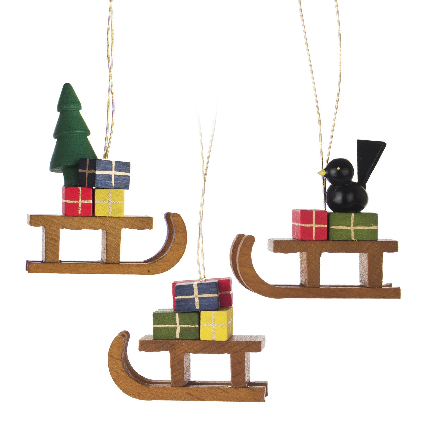 Drei hängende Holzschlitten-Dekorationen mit Geschenken; einer mit einem grünen Baum, einer mit einem schwarzen Vogel. im Dregeno Online Shop günstig kaufen