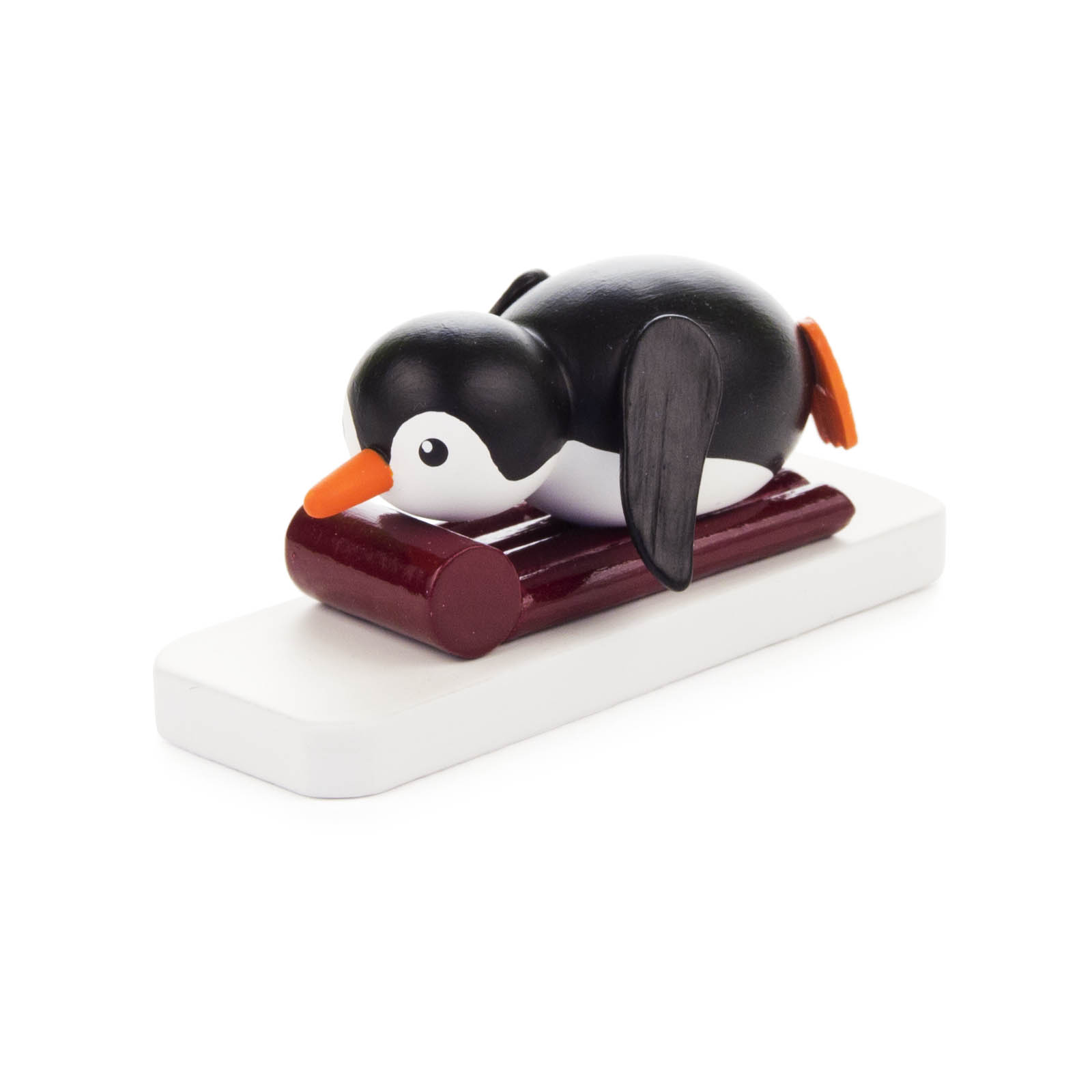 Ein Holzpinguin liegt auf einem Bauchbrett, Flügel angelegt und Schnabel nach vorne gerichtet. im Dregeno Online Shop günstig kaufen