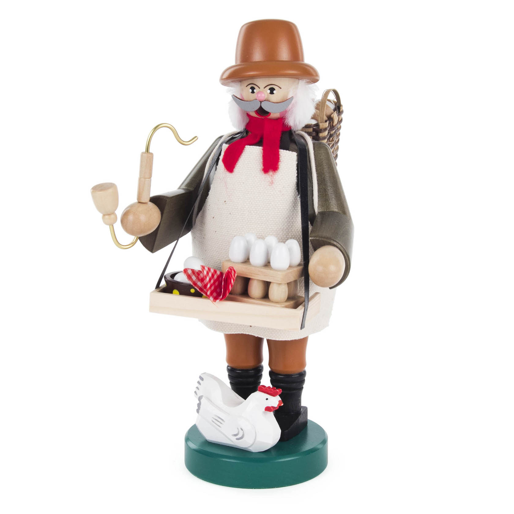 Ein Räuchermann in traditioneller Kleidung hält eine Holzschachtel mit weißen Eiern und einer rot karierten Stoffschleife. Neben ihm steht eine weiße Henne. im Dregeno Online Shop günstig kaufen