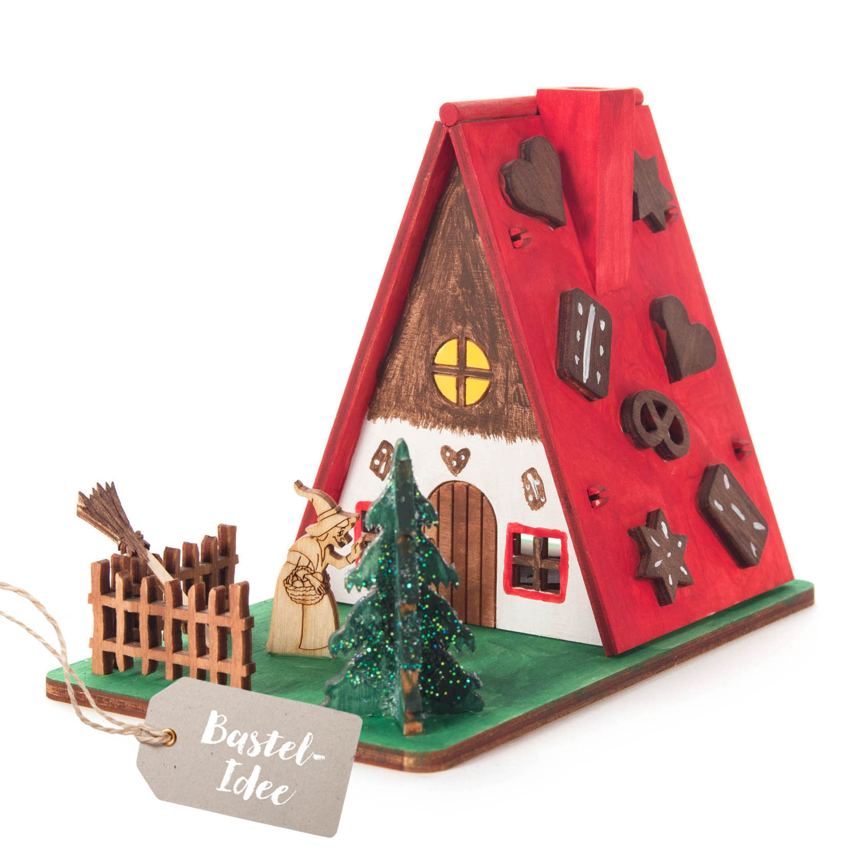 Ein detailliertes Bastelset eines Hexenhauses aus Holz. Es zeigt ein gemütliches Haus mit einem roten Dach, verziert mit kleinen Holzformen. Vor dem Haus steht eine Hexenfigur, sowie ein kleiner Baum und ein Zaun. im Dregeno Online Shop günstig kaufen
