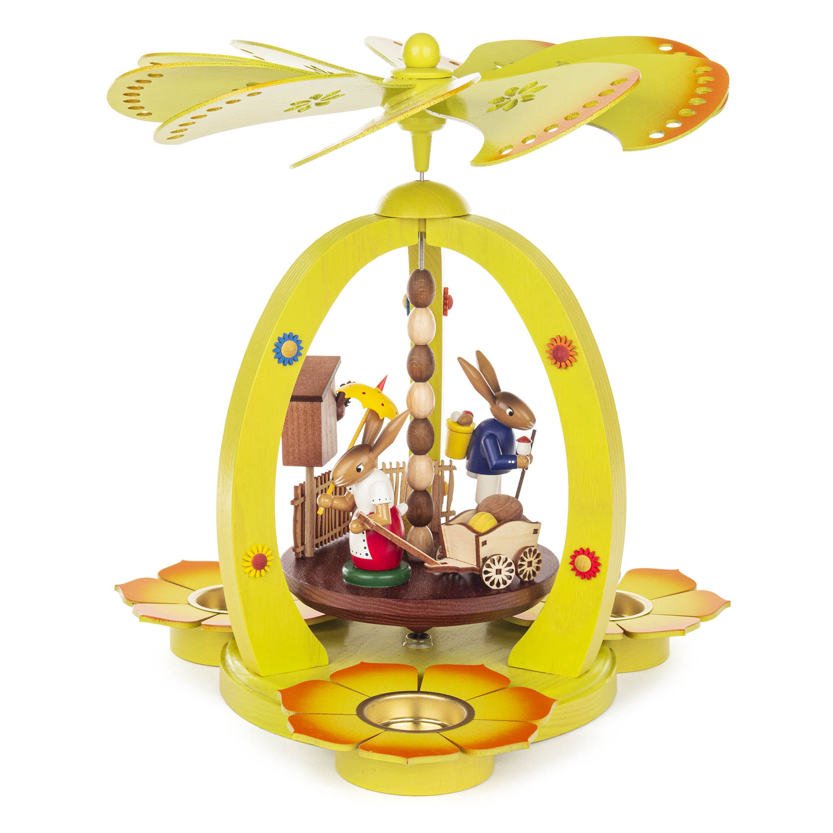 Farbenfrohe Teelichtpyramide mit zwei Hasen, einer zieht einen Handwagen, der andere hält einen Schirm. Blumenmuster schmücken die Pyramide. im Dregeno Online Shop günstig kaufen