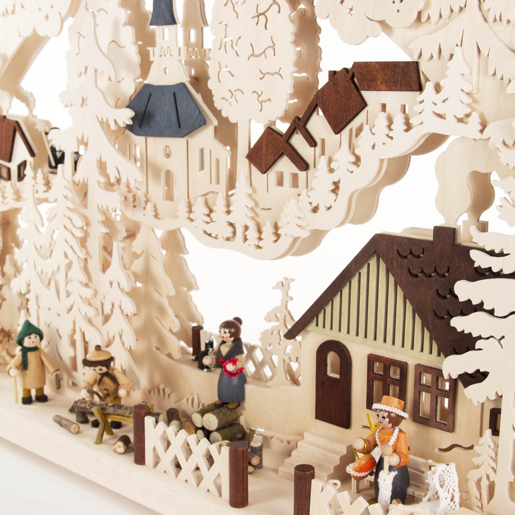Holz-Schwibbogen mit Dorfidylle: verschiedene Figuren, darunter Kinder beim Schlittenfahren und Erwachsene neben einem Haus. Im Hintergrund steht eine Kirche.