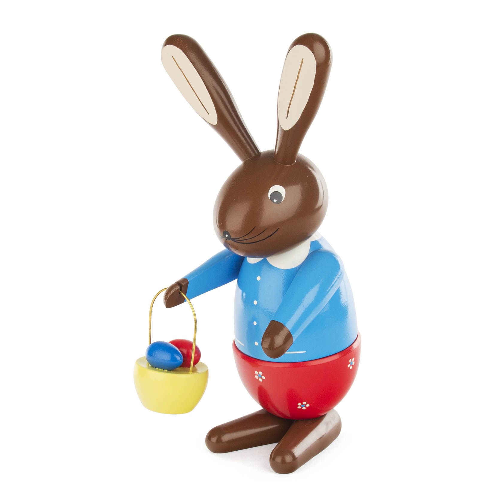 Farbig bemalte Hasenfigur in traditioneller Kleidung mit gelbem Handkorb, in dem bunte Eier liegen. Die Häsin hat einen blauen Oberteil und rote Hose. im Dregeno Online Shop günstig kaufen