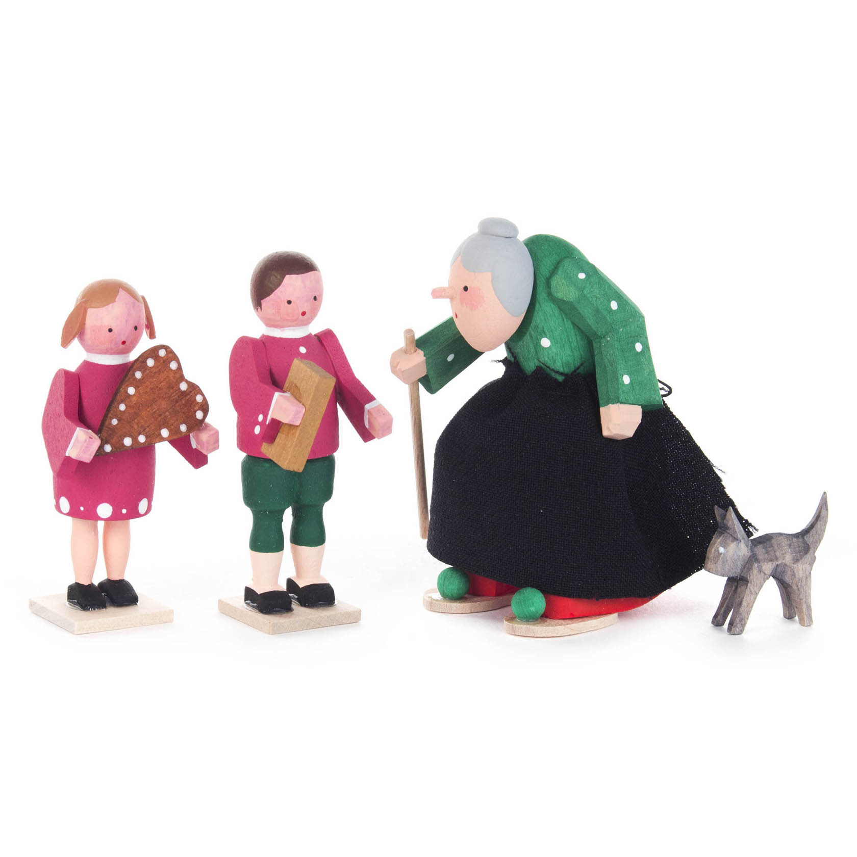 Holzfiguren: Eine Hexe mit grünem Mantel und Stock beugt sich zu Hänsel in grüner Hose und Gretel in rosa Kleid mit Lebkuchen, sowie ein grauer Kater. im Dregeno Online Shop günstig kaufen