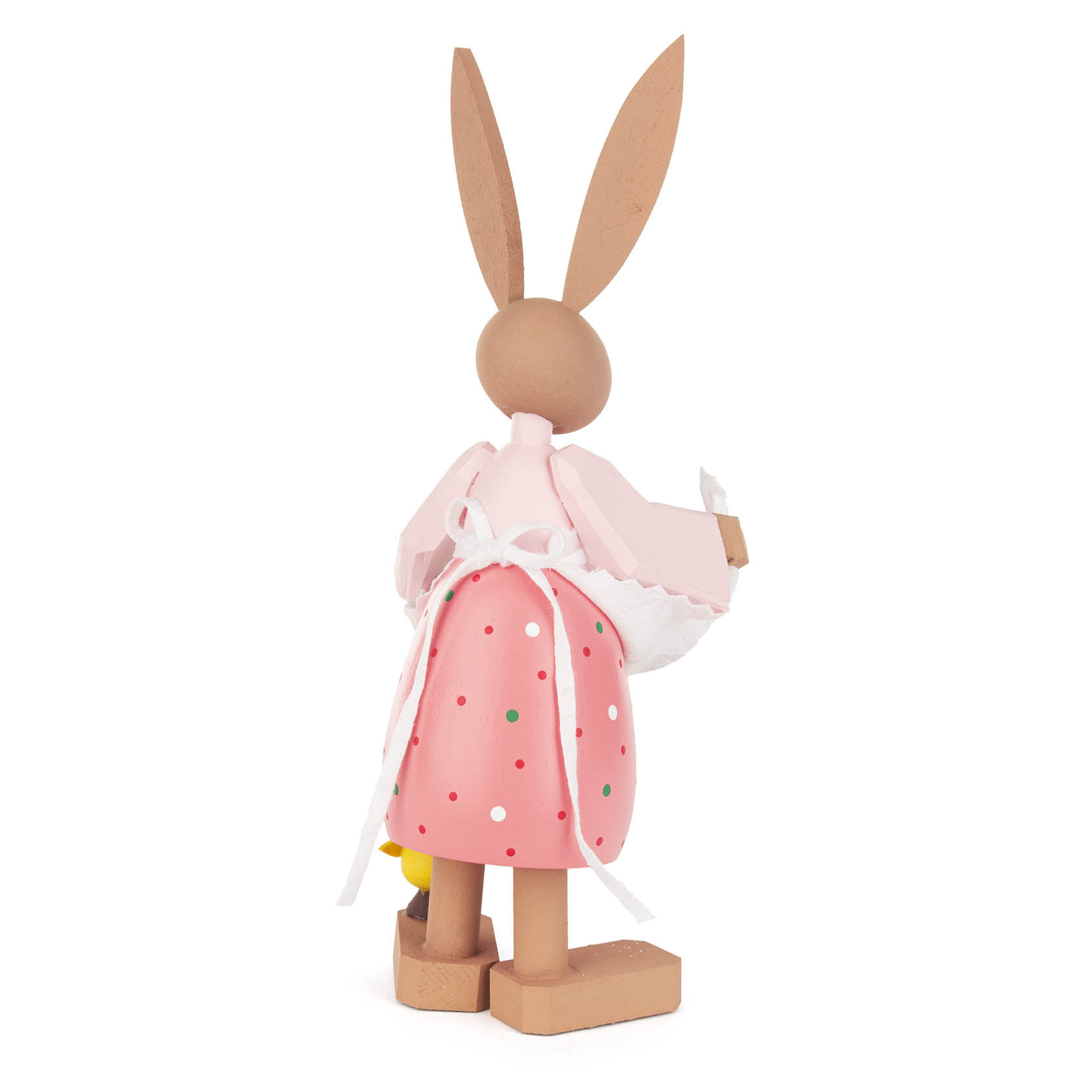 Holzfigur einer Häsin mit langen Ohren, die eine rosa Schürze mit Punkten und ein weißes Kopftuch trägt, von hinten zu sehen.
