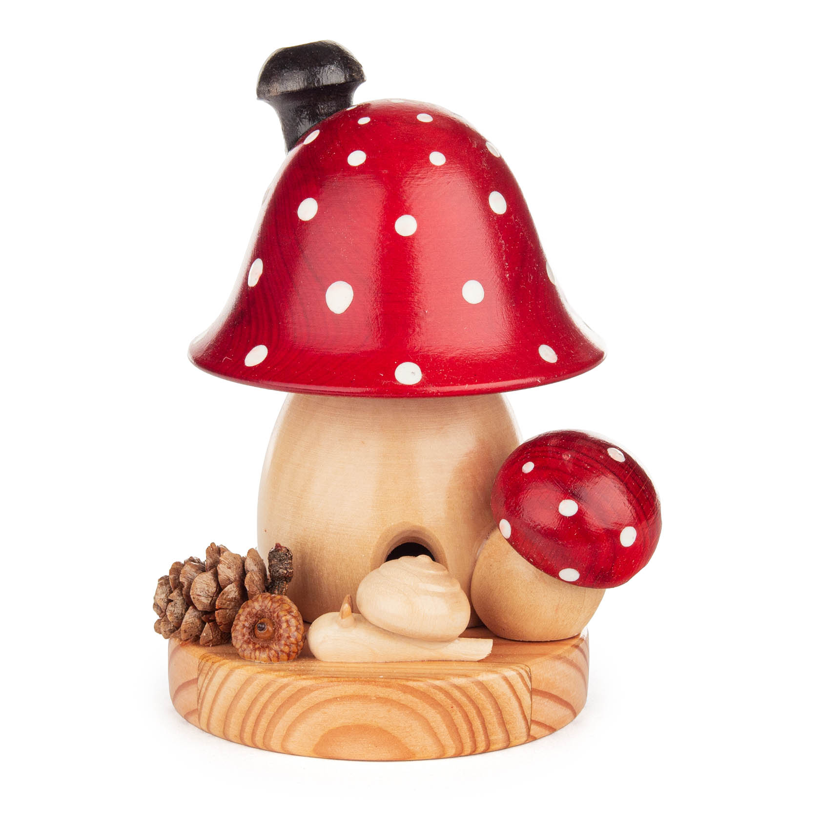 Kleiner Räucherpilz in Form eines Fliegenpilzes mit rotem, gepunktetem Hut, sitzend auf einer Holzplattform, dekoriert mit Tannenzapfen und kleiner Schnecke. im Dregeno Online Shop günstig kaufen