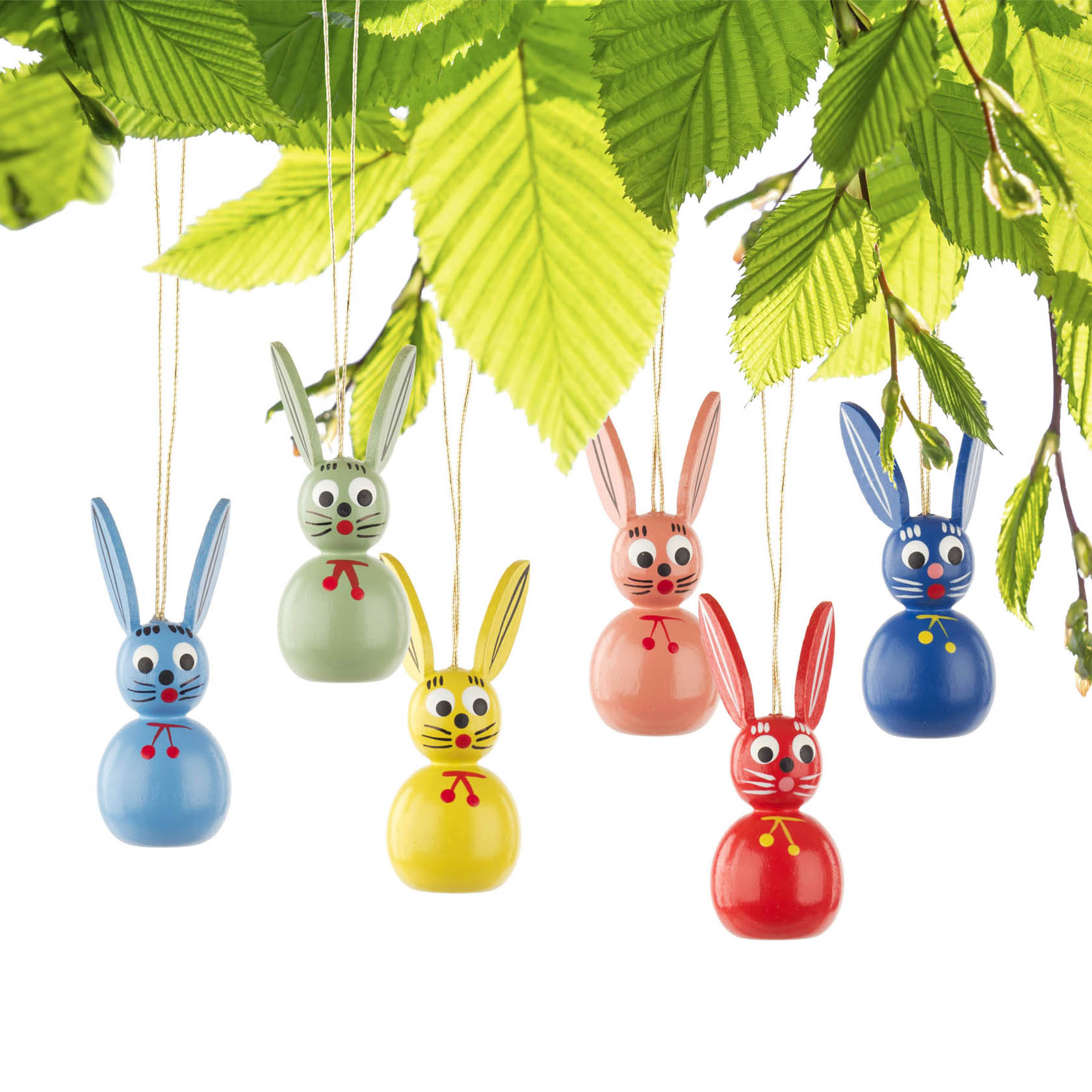 Sechs bunte Osterhasen-Dekorationen hängen an Fäden: ein blauer, ein grüner, ein gelber, ein rosa und zwei rote, alle mit kleinen Schleifen.