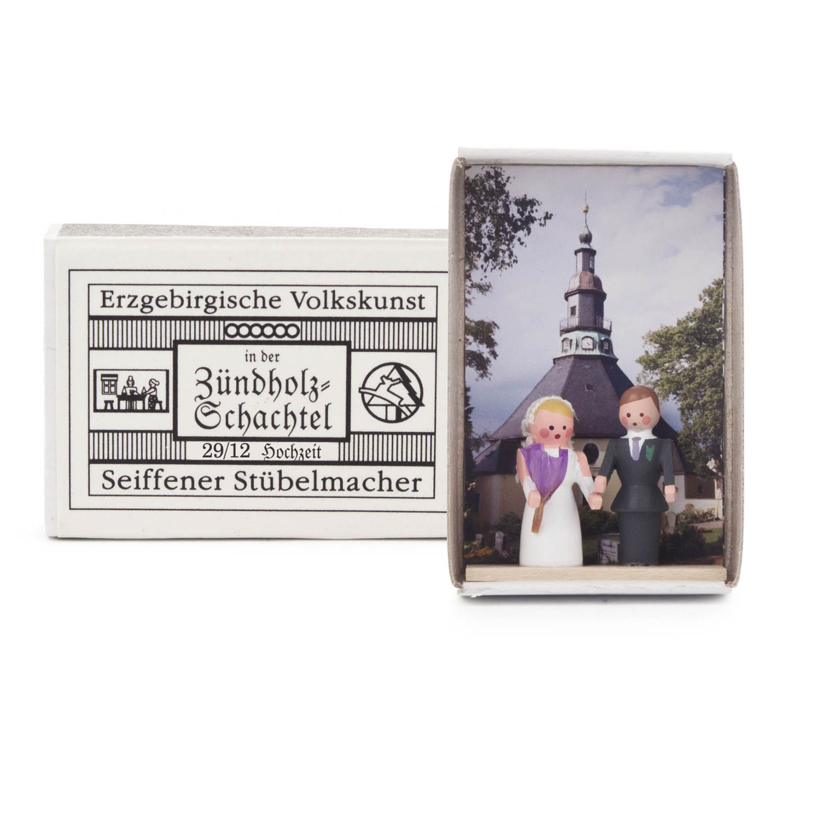 Kleine Holzfiguren eines Brautpaares in einer Schachtel, vor einem Hintergrundbild einer Kirche. Die Schachtel ist von 'Erzgebirgische Volkskunst'. im Dregeno Online Shop günstig kaufen
