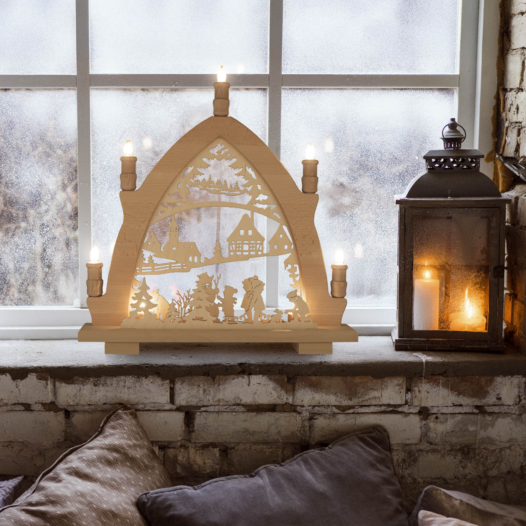 Ein hölzerner Leuchterbogen aus Buche mit LED-Beleuchtung steht auf einer Fensterbank. Er zeigt Skifahrer, Kinder und ein Haus im Winterlandschafts-Stil.