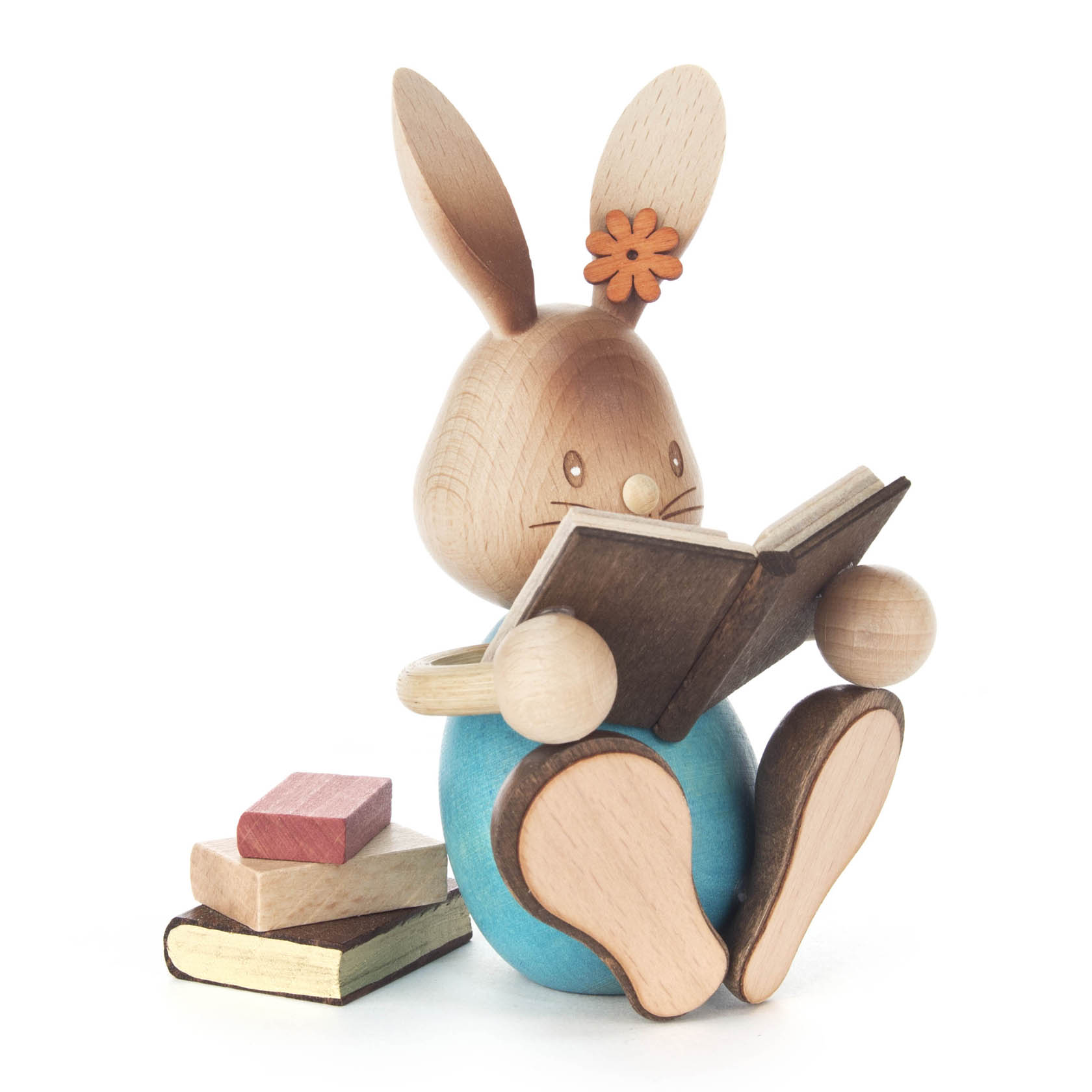 Holzfigur eines sitzenden Hasen mit orangefarbener Blume am Ohr, der ein Buch liest. Neben ihm liegen drei weitere Bücher. im Dregeno Online Shop günstig kaufen