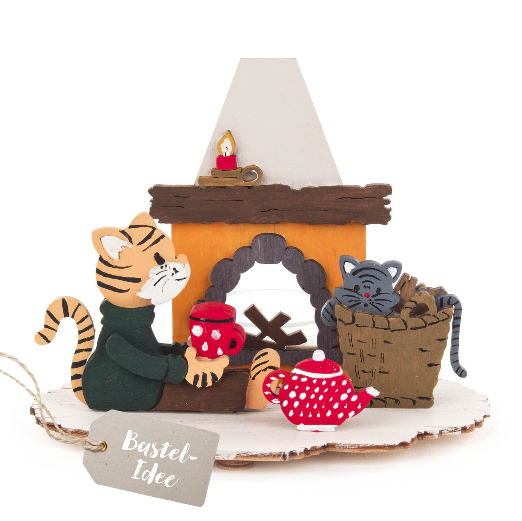 A wooden craft set depicting two cats by a fireplace, one sitting with a red mug and the other sleeping in a basket with firewood. im Dregeno Online Shop günstig kaufen