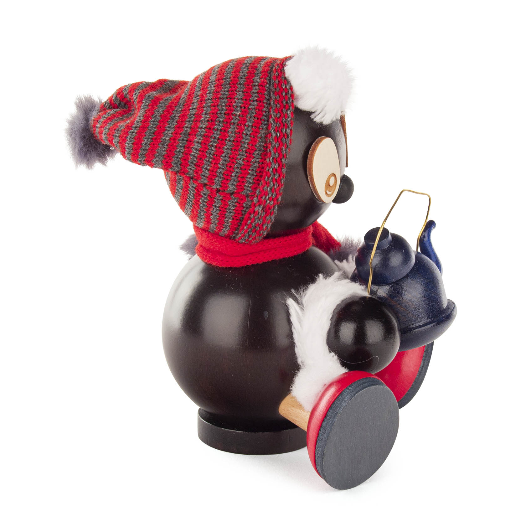 Holzräucherfigur eines stilisierten Tieres mit großer Brille, roter Mütze und Schal, hält eine blaue Teekanne. Figur sitzt auf einem Holzsockel.