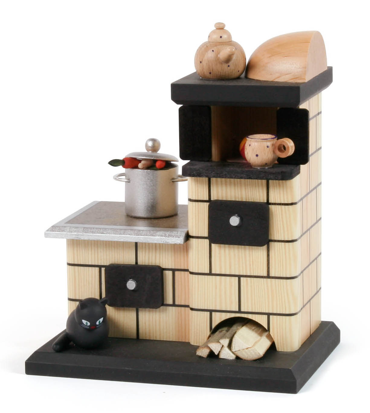 Holzmodell eines traditionellen Kachelofens mit Topf und Teekanne auf der Ablage. Es gibt eine schwarze Katze am Boden, sowie Holzscheite daneben. im Dregeno Online Shop günstig kaufen