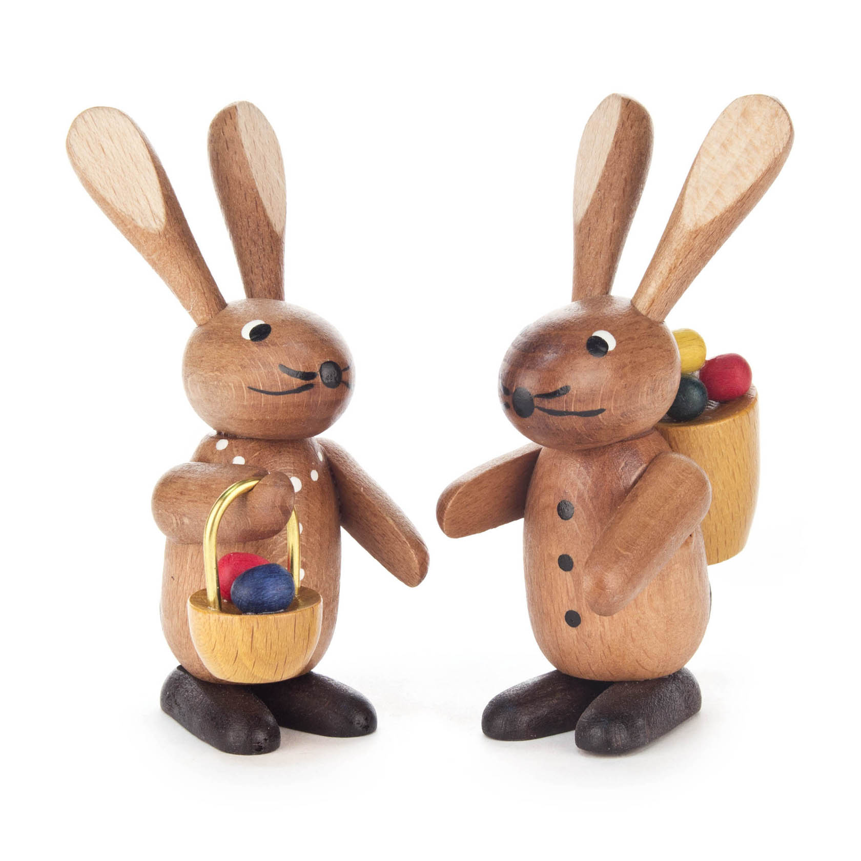 Zwei aus Holz gefertigte Hasenfiguren in hellbraun, eine trägt einen Korb in der Hand mit Eiern und die andere hat einen Rucksack mit Eiern. im Dregeno Online Shop günstig kaufen
