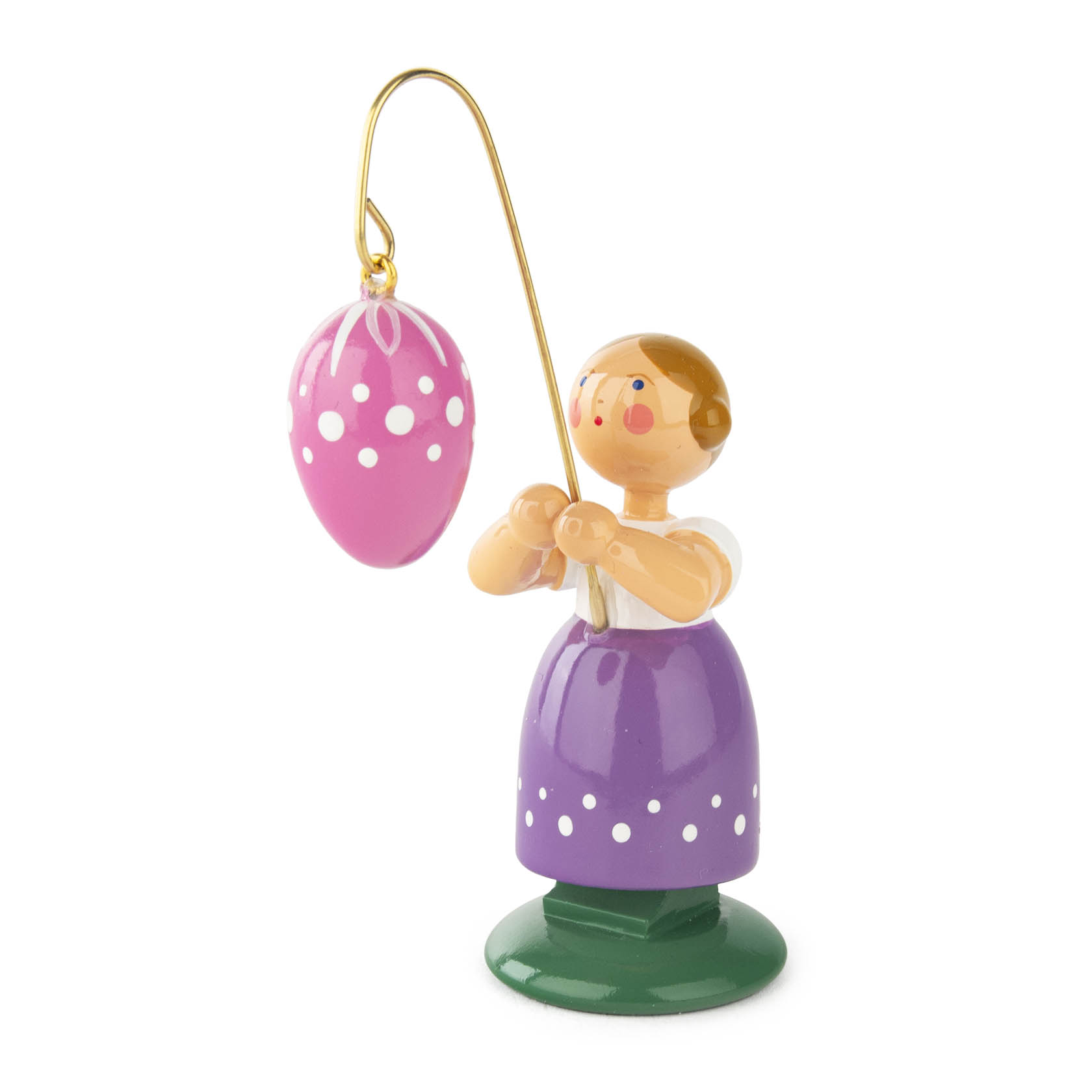 Holzfigur eines Mädchens in lila Kleid, hält an einem goldenen Haken ein rosa Osterei mit weißen Punkten. im Dregeno Online Shop günstig kaufen