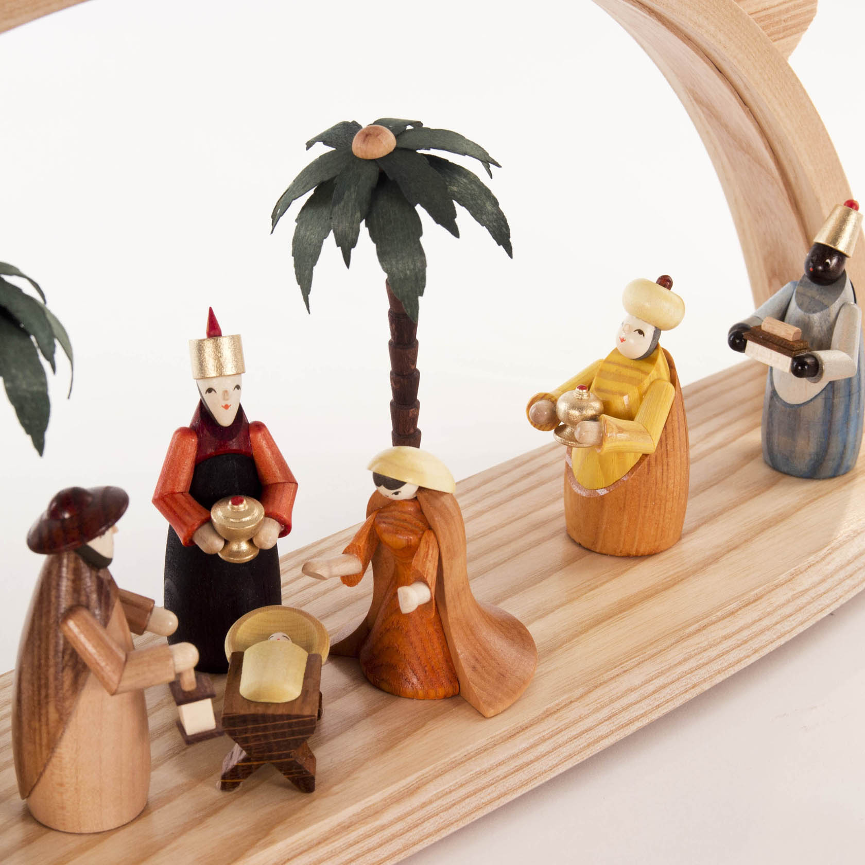 Ein farbiger Schwibbogen zeigt die Geburt Christi mit handgeschnitzten Holzfiguren. Maria, Josef und die Heiligen Drei Könige sind präsent.