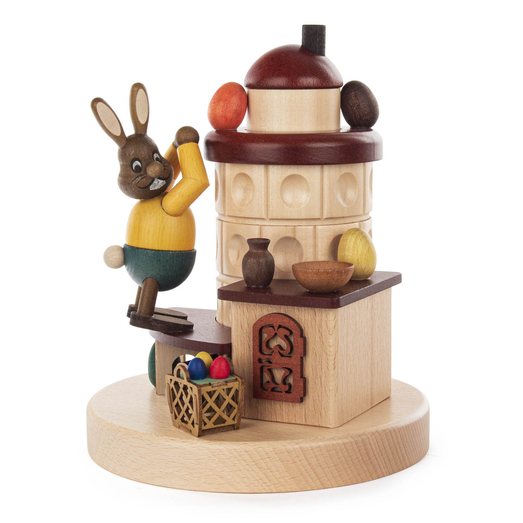 Dekorativer Räucherofen aus Holz mit einem Hasen und bunt bemalten Ostereiern. Der Hase hält eine gelbe Karotte und steht auf einer Holzplattform. im Dregeno Online Shop günstig kaufen