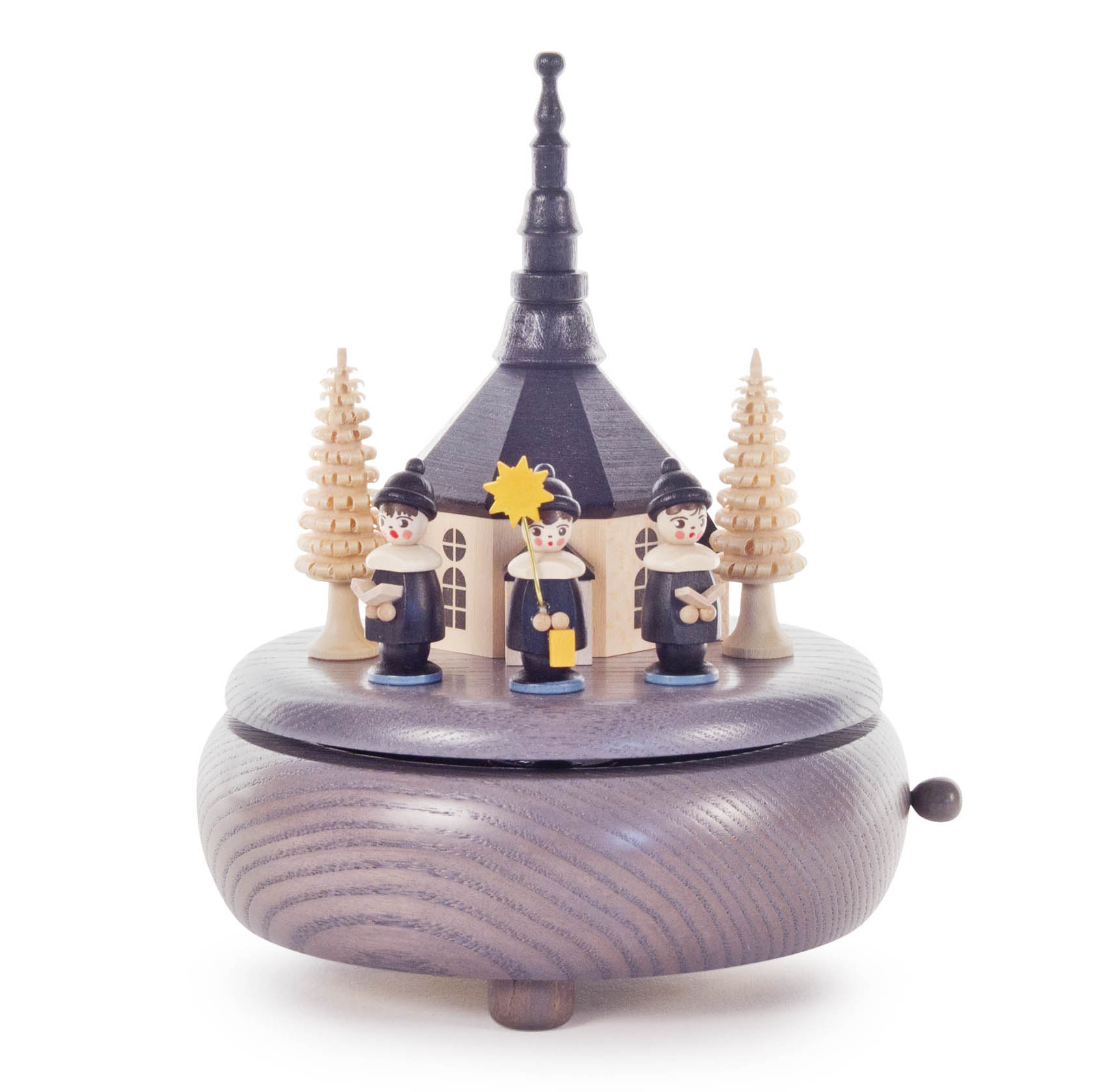 Graue Spieldose mit Seiffener Kirche und drei Kurrendesängern. Die Sänger tragen schwarze Kittel und stehen umgeben von kleinen Tannenbäumen. im Dregeno Online Shop günstig kaufen