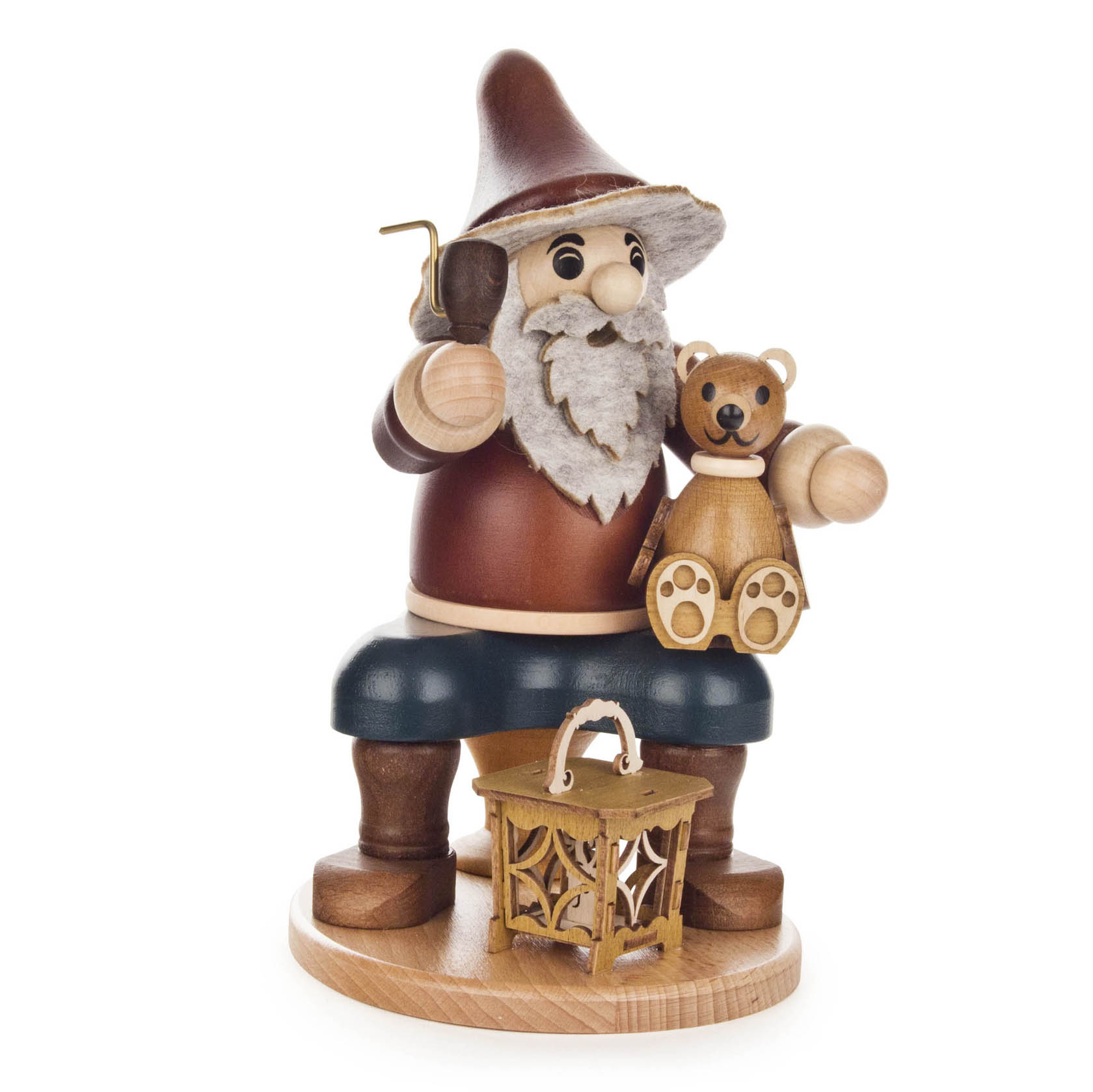 Ein sitzender Räuchermann-Wichtel mit braunem Hut und rotem Mantel hält in einer Hand eine Pfeife und in der anderen einen hölzernen Teddybär; vor ihm eine Laterne. im Dregeno Online Shop günstig kaufen