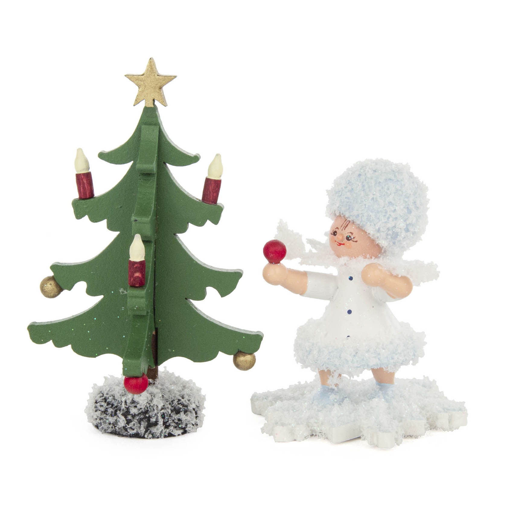 Holzfigur Schneeflöckchen mit weißen Kleid und blauen Haaren steht neben einem dekorierten Tannenbaum mit Kerzen und Stern auf verschneitem Boden. im Dregeno Online Shop günstig kaufen