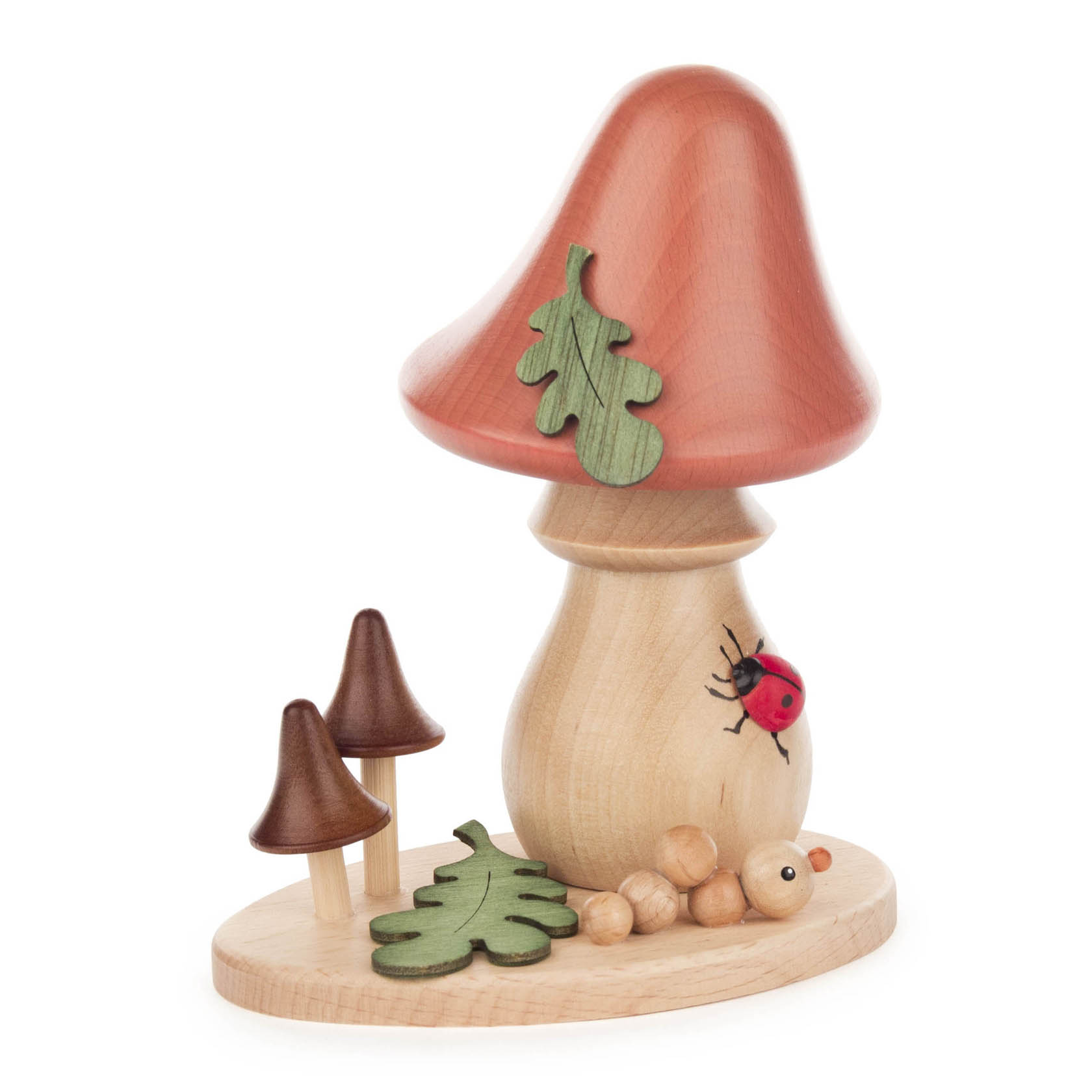 Handgefertigte hölzerne Pilzfigur mit rotem Hut, verziert mit einem grünen Eichenblatt und einem Marienkäfer, auf einer Holzplatte mit zwei kleinen braunen Pilzen. im Dregeno Online Shop günstig kaufen