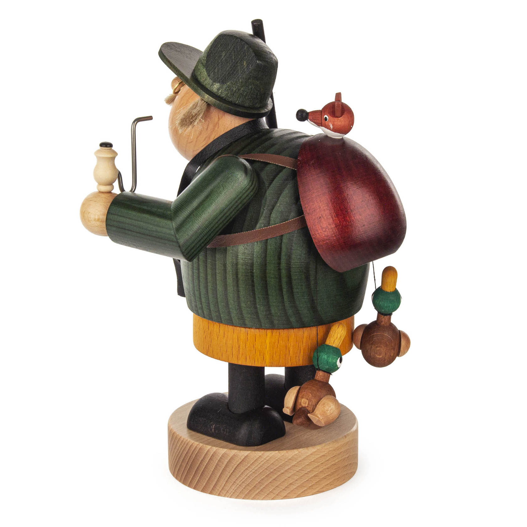 Holzfigur eines Jägers mit grüner Jacke, Pfeife, Rucksack und einem Vogelkopf auf dem Rucksack.