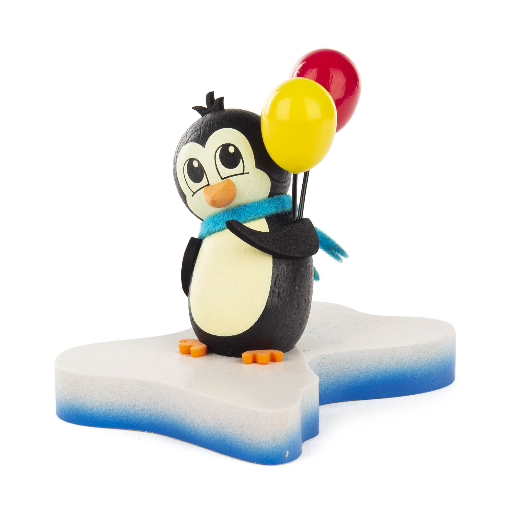 Eine Figur eines lächelnden Pinguins mit blauem Schal, der drei bunte Luftballons hält und auf einer Eisfläche steht. im Dregeno Online Shop günstig kaufen
