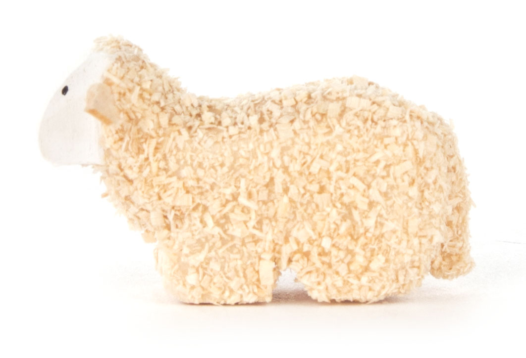 Dekoratives, beige Schaf aus Holzspänen liegend dargestellt, mit weißem Kopf und schwarzem Auge.
