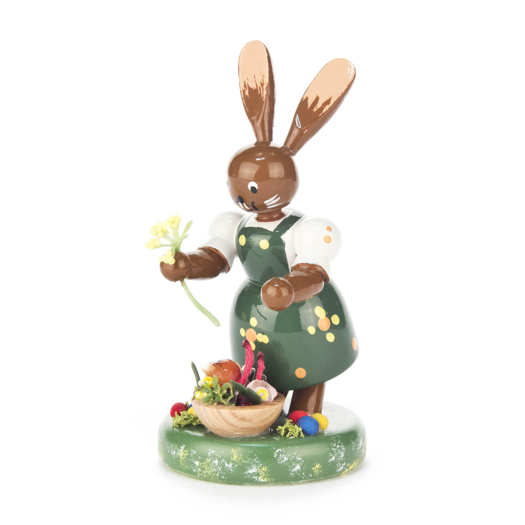 Holzfigur einer Häsin als Gärtnerin mit gepunkteter Schürze, die eine Blume hält. Vor ihr steht ein Korb mit Gemüse. im Dregeno Online Shop günstig kaufen
