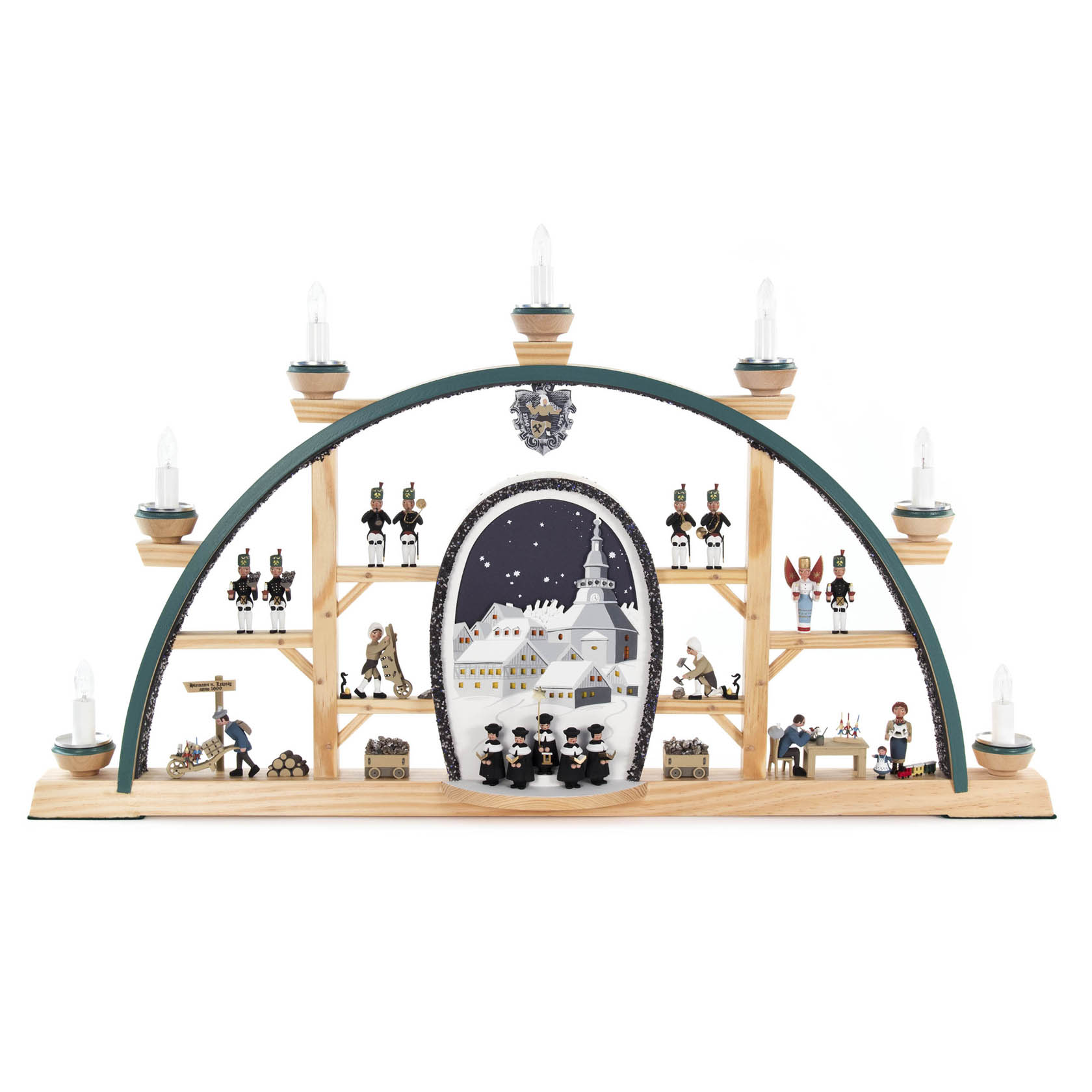 Ein Schwibbogen zeigt eine Szene mit einem Seiffener Dorf, Kurrende-Sängern, einem Weihnachtsbaum und Erzgebirgsfiguren. Er ist elektrisch beleuchtet. im Dregeno Online Shop günstig kaufen