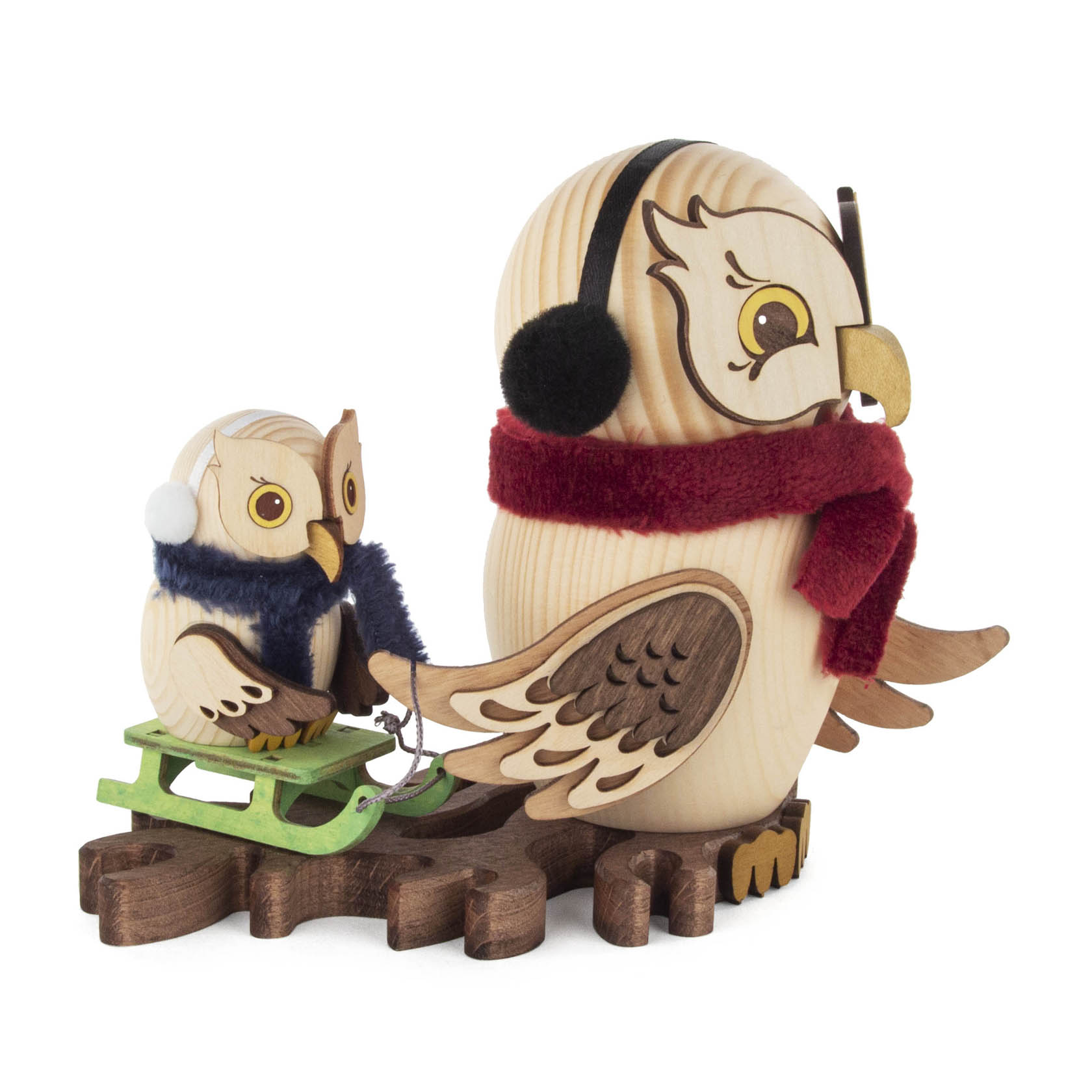Holzeulenfigur in Winterkleidung: Große Eule mit roten Ohrwärmern und Schal zieht Schlitten, auf dem eine kleine Eule mit blauen Ohrwärmern sitzt.