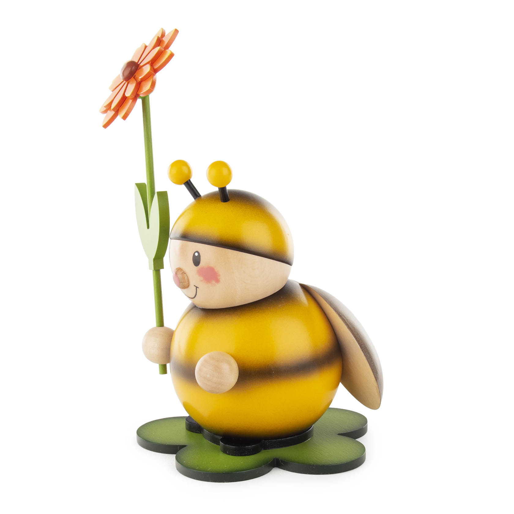 Holzfigur einer lächelnden Hummel, die eine orangefarbene Blume in der rechten Hand hält. Die Hummel steht auf einem grünen Blattsockel.