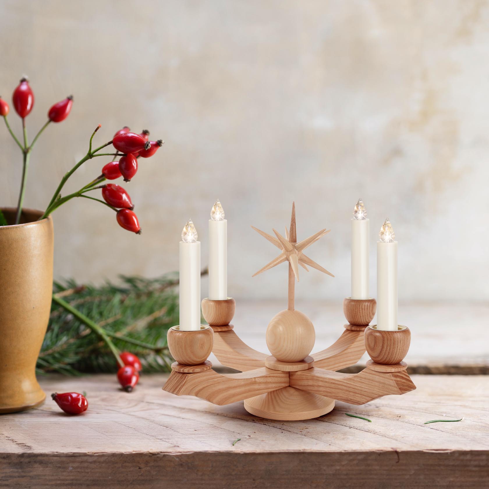 A small natural wooden Advent candle holder with a star on top, designed to hold 22mm diameter candles. It has five candle holders and a central decorative star.