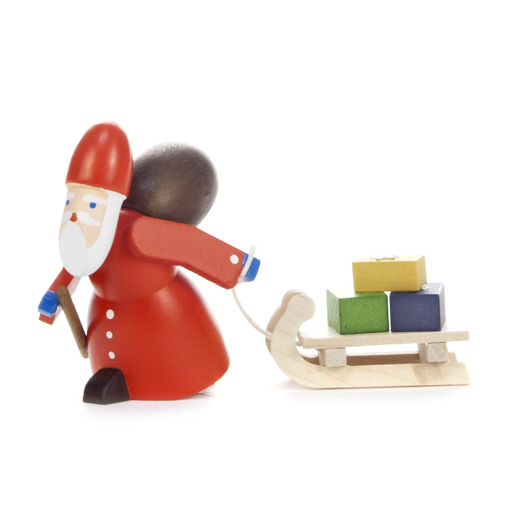Holzfigur von Ruprecht mit rotem Mantel, Sack auf dem Rücken, zieht einen Schlitten mit bunten Geschenken. im Dregeno Online Shop günstig kaufen