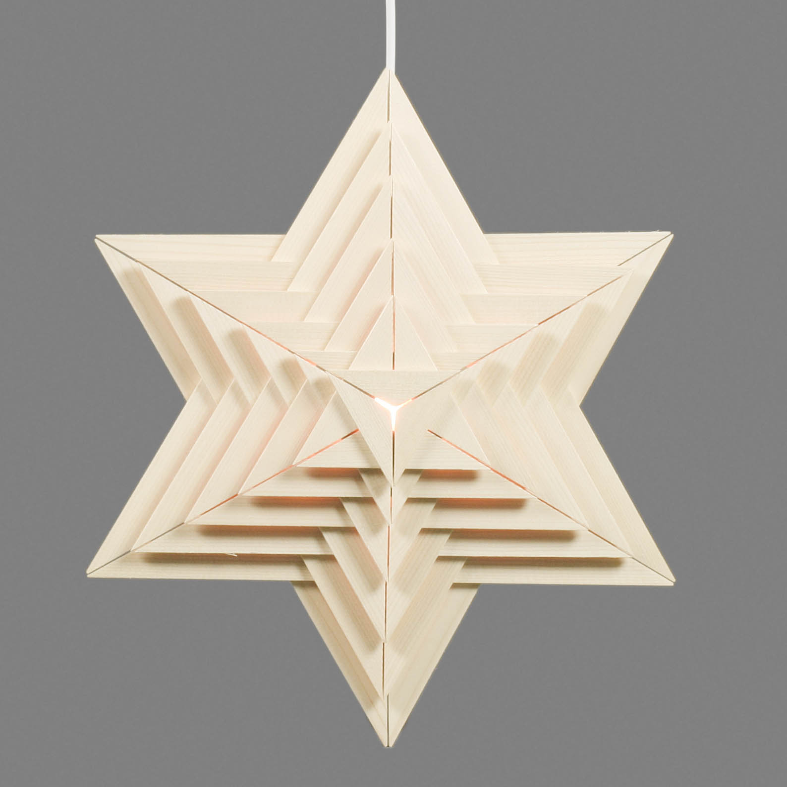 Ein sechszackiger Weihnachtsstern aus Holz mit elektrischer Beleuchtung.