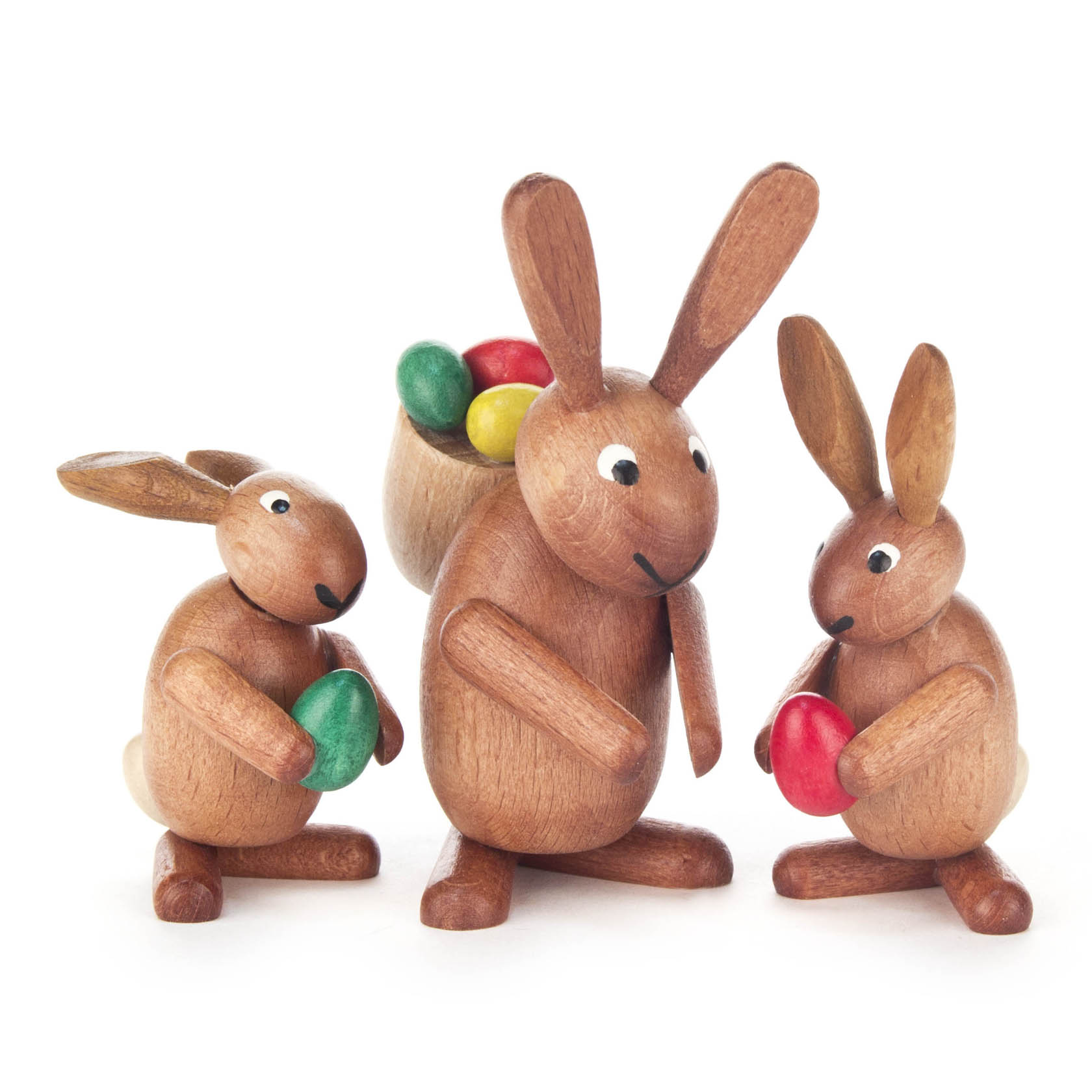 Drei braun gebeizte Holzhasenfiguren; ein Hase trägt einen Korb mit bunten Eiern, die anderen beiden Hasen halten jeweils ein Ei in grüner und roter Farbe. im Dregeno Online Shop günstig kaufen