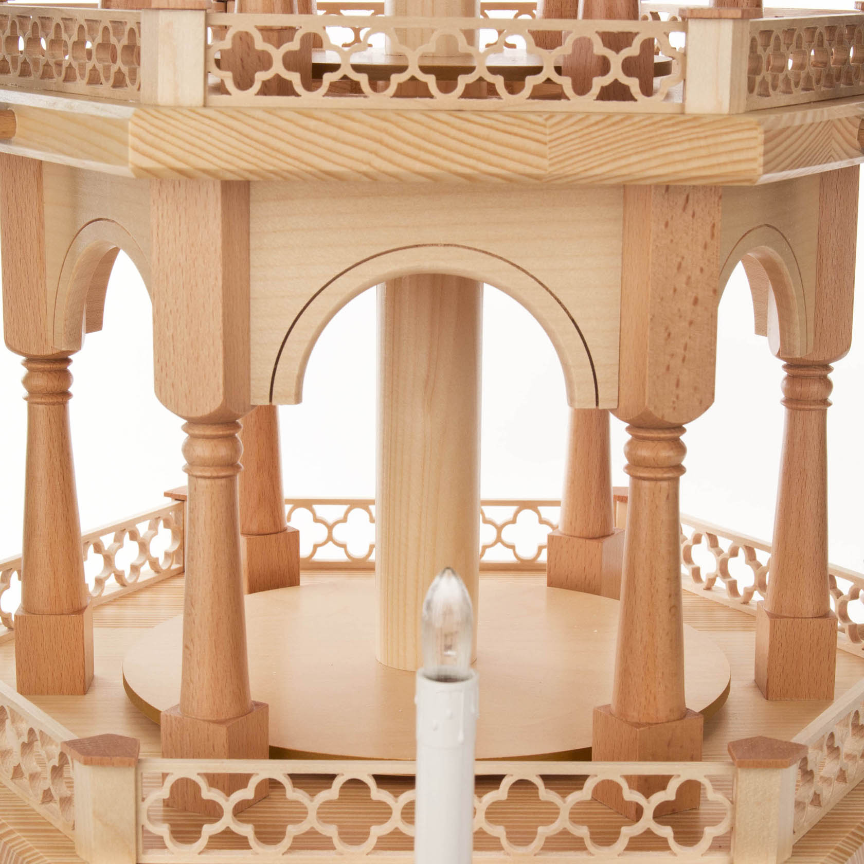 A three-tiered wooden pyramid structure with electric lighting and motor, featuring elegant arches and pillars.