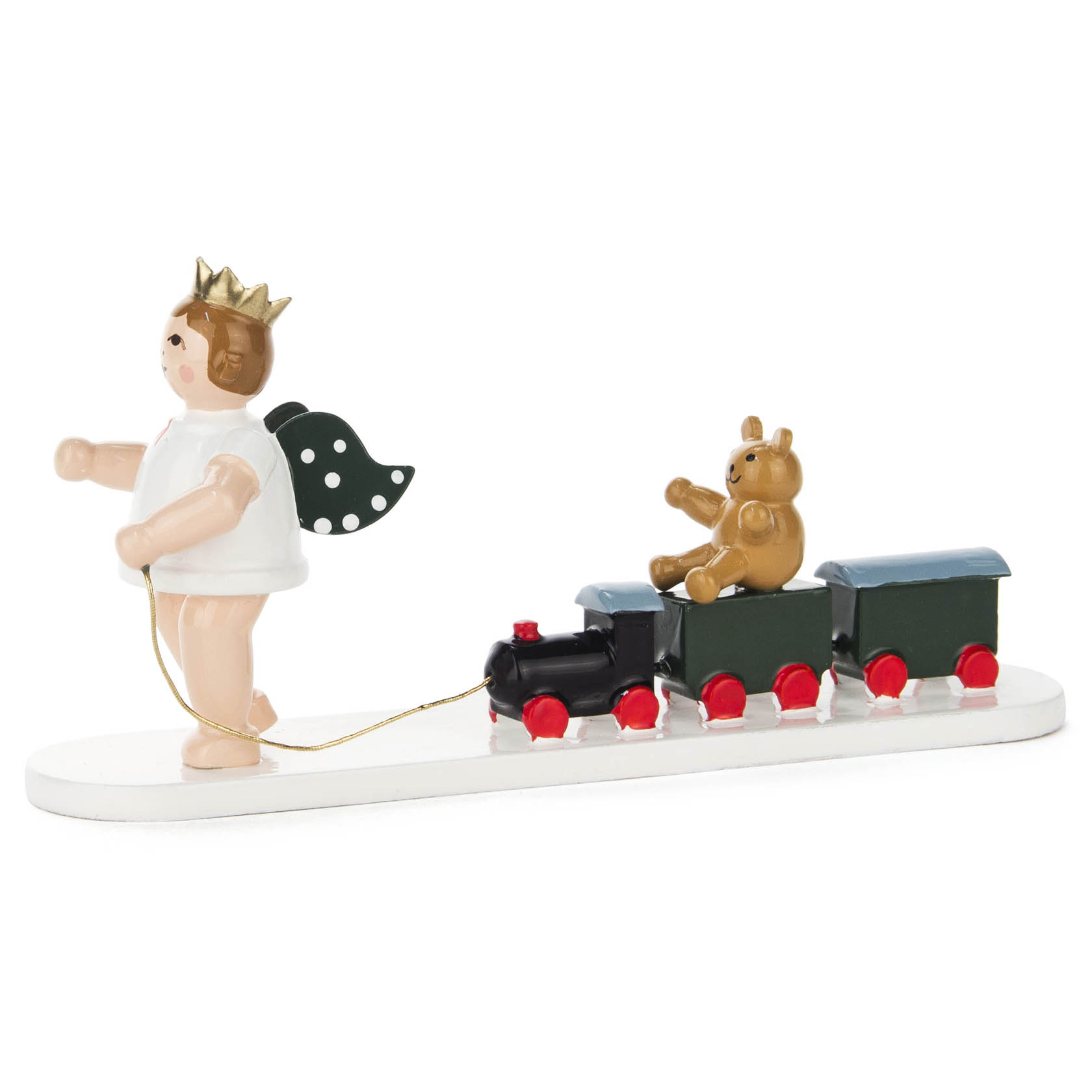 Eine Engel-Figur mit Krone zieht eine kleine schwarze Lokomotive mit zwei grünen Waggons. Auf dem ersten Waggon sitzt ein brauner Teddybär.