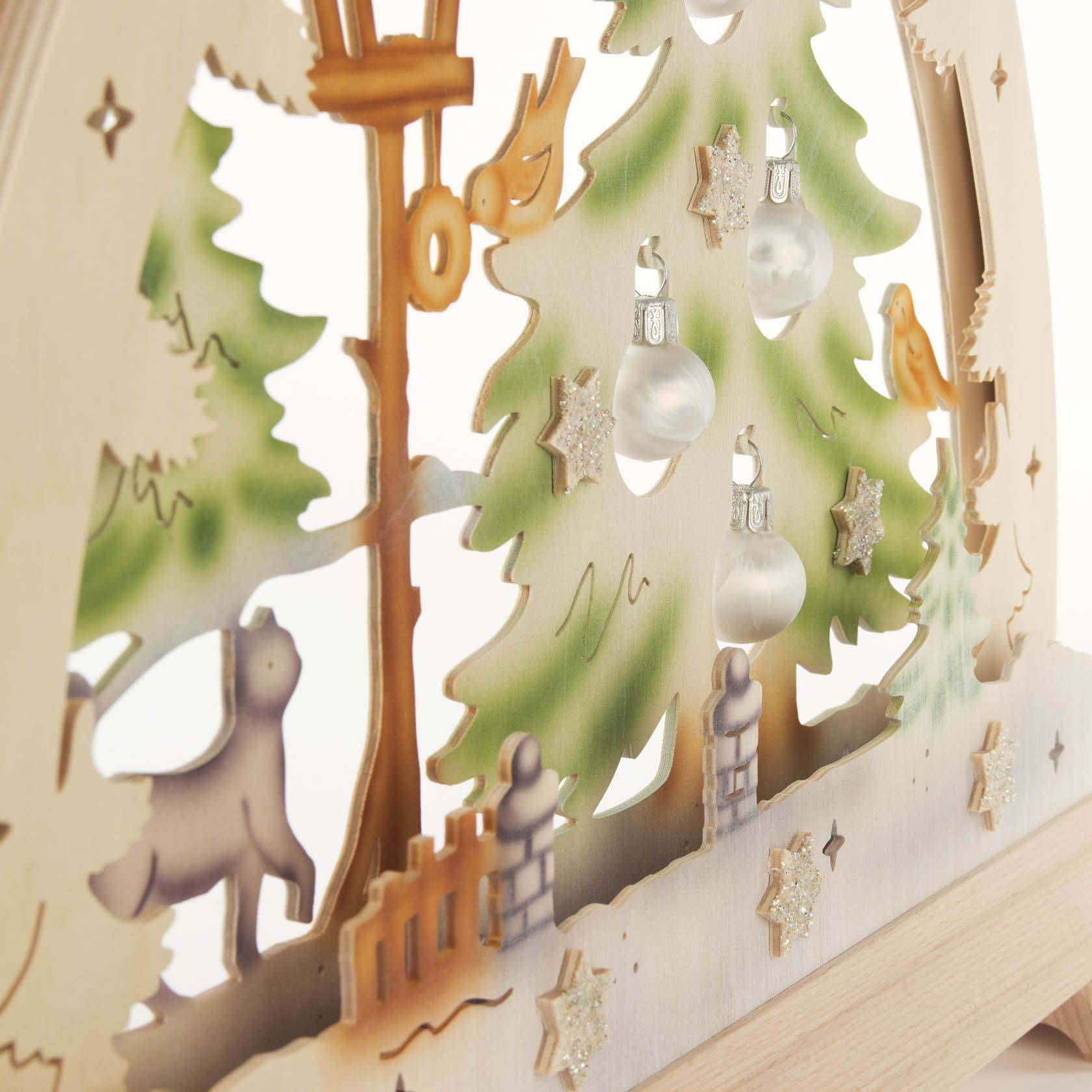 Holzbogen mit Katze und Vögeln umgeben von Tannenbaum mit Weihnachtskugeln, LED-Lichter sorgen für farbige Beleuchtung.