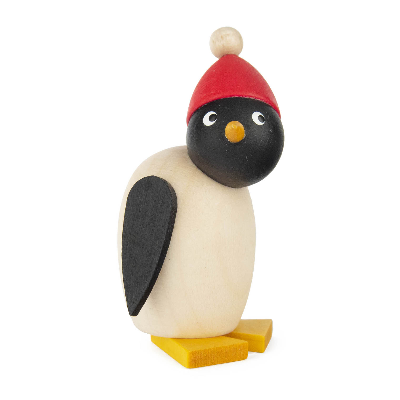 Holzfigur eines Pinguinbabys mit roter Mütze und gelben Füßen, mit fröhlichem Ausdruck. Der Körper ist beige, der Kopf ist schwarz.